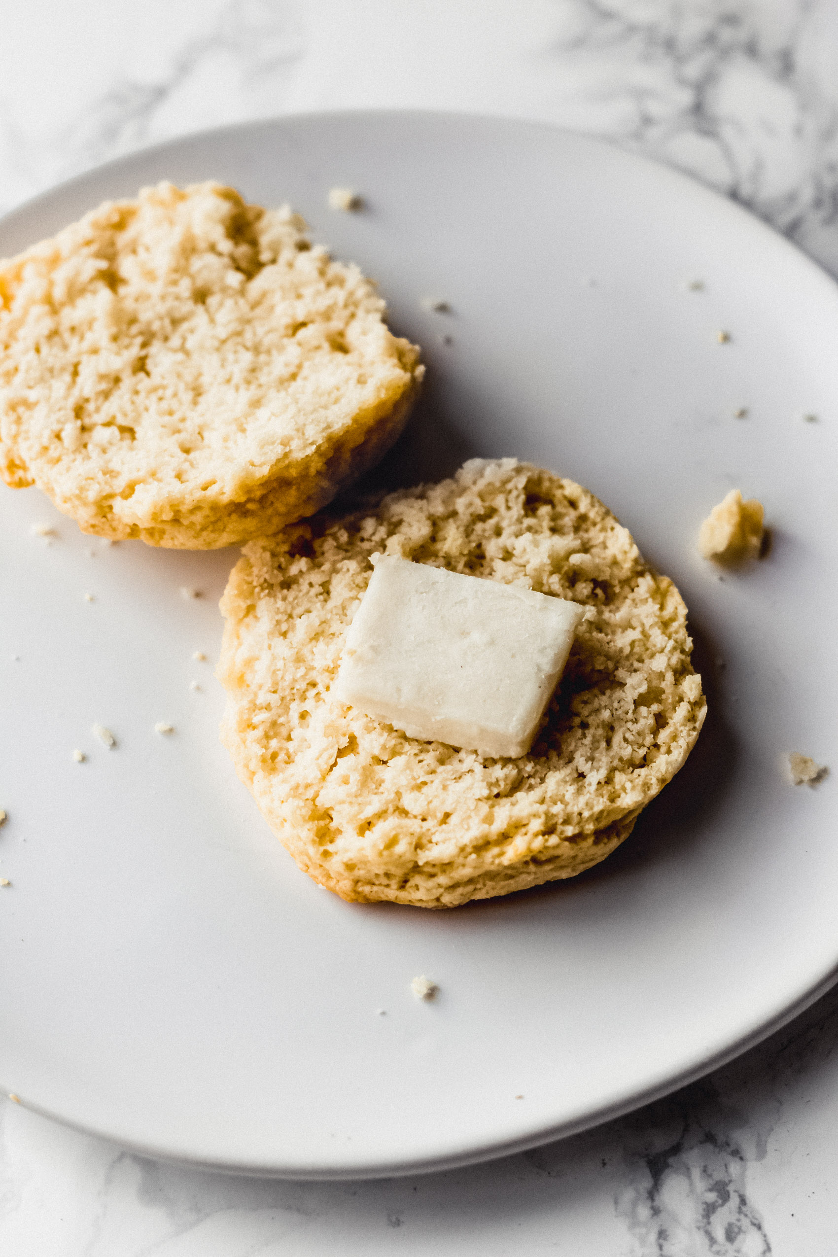 a vegan biscuit that has been sliced in half and topped with butter