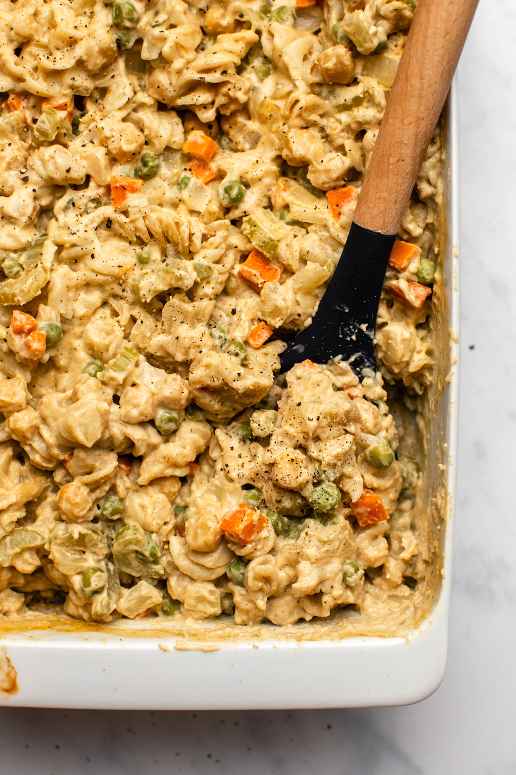 a spoon scooping out a serving of vegan chickpea noodle casserole