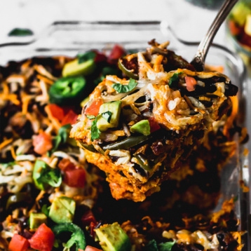 a spoon scooping out a serving of vegan enchilada casserole