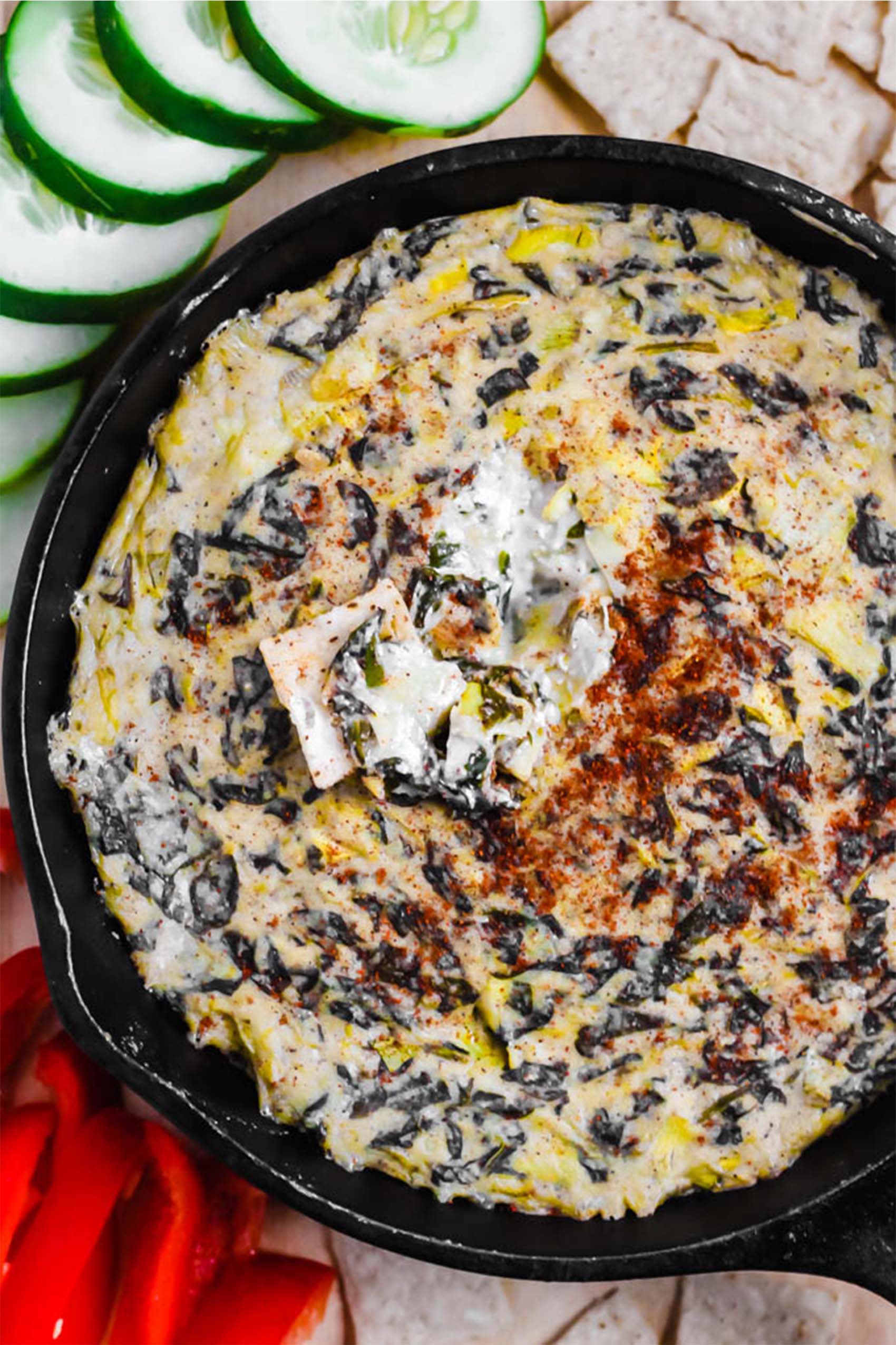 a skillet of vegan spinach artichoke dip