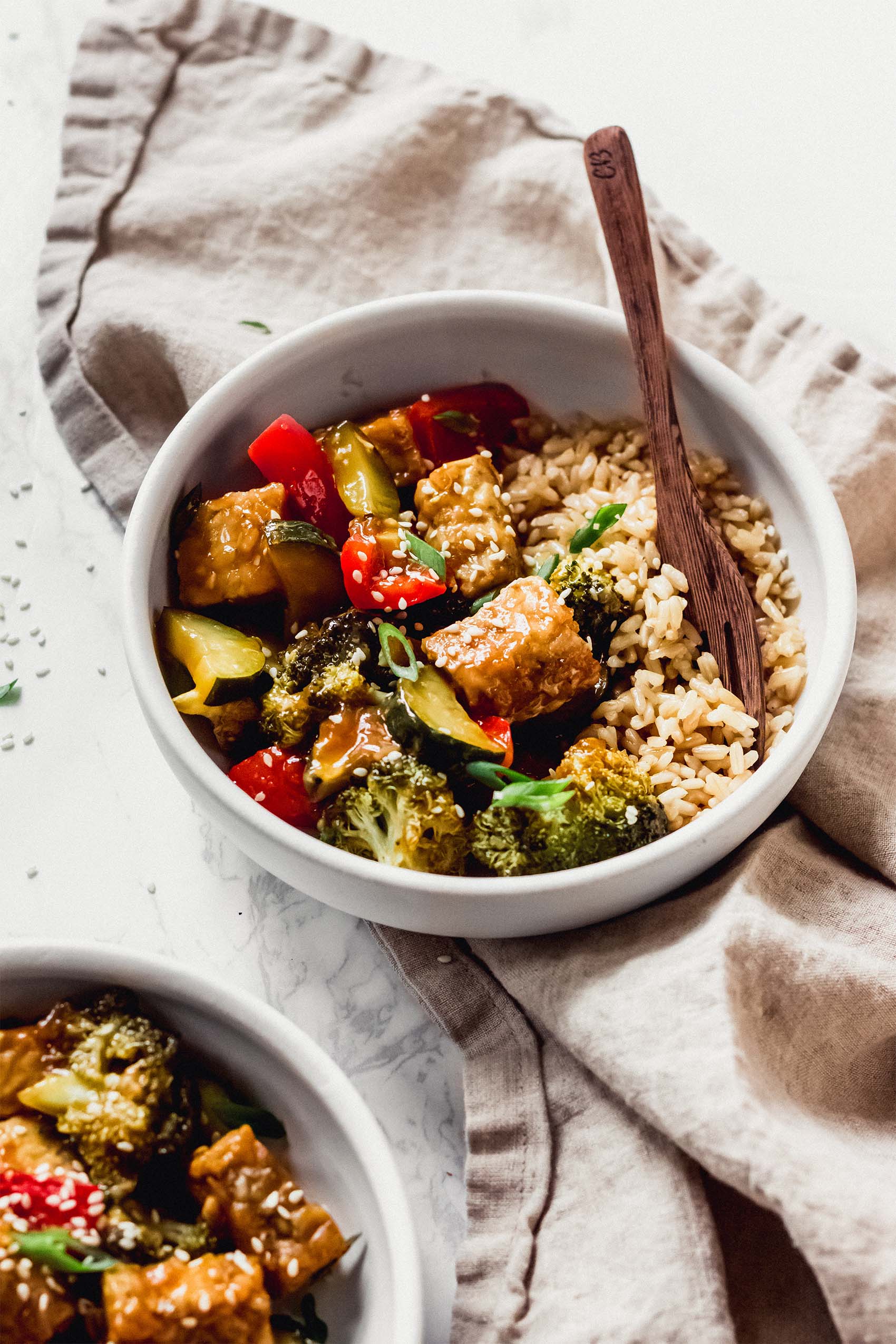 a bowl of brown rice with a tempeh and vegetable stir fry