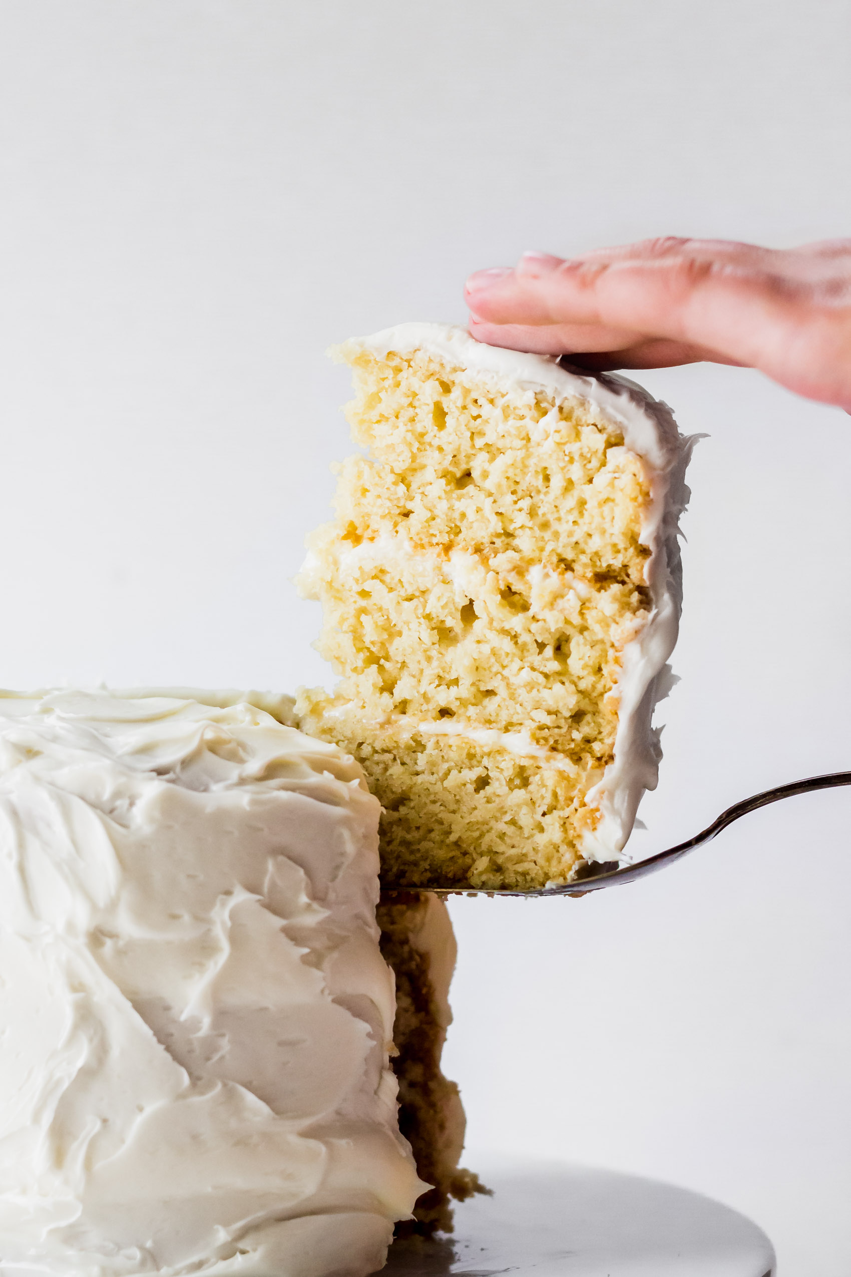 a slice of three-layer vegan vanilla cake being served