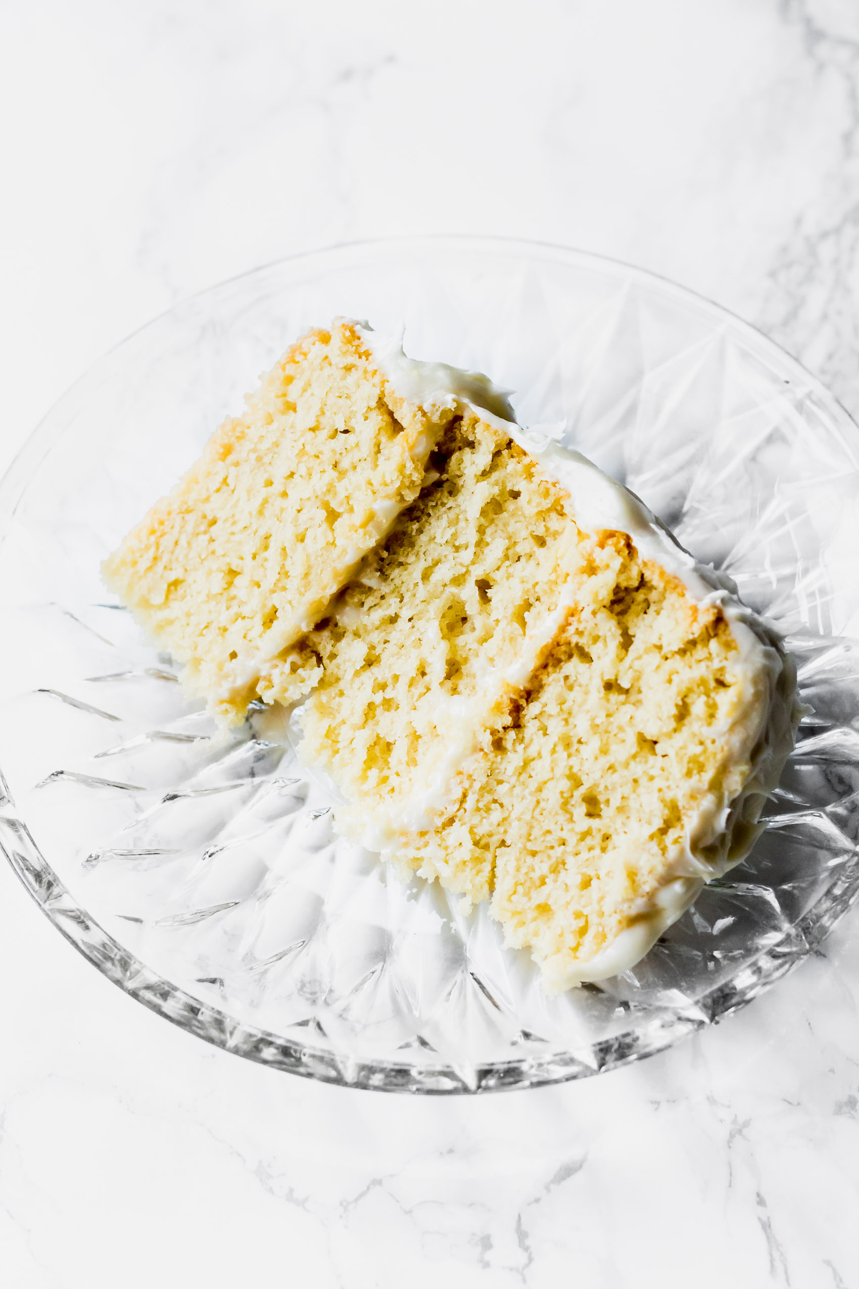a slice of layered vegan vanilla cake on a plate