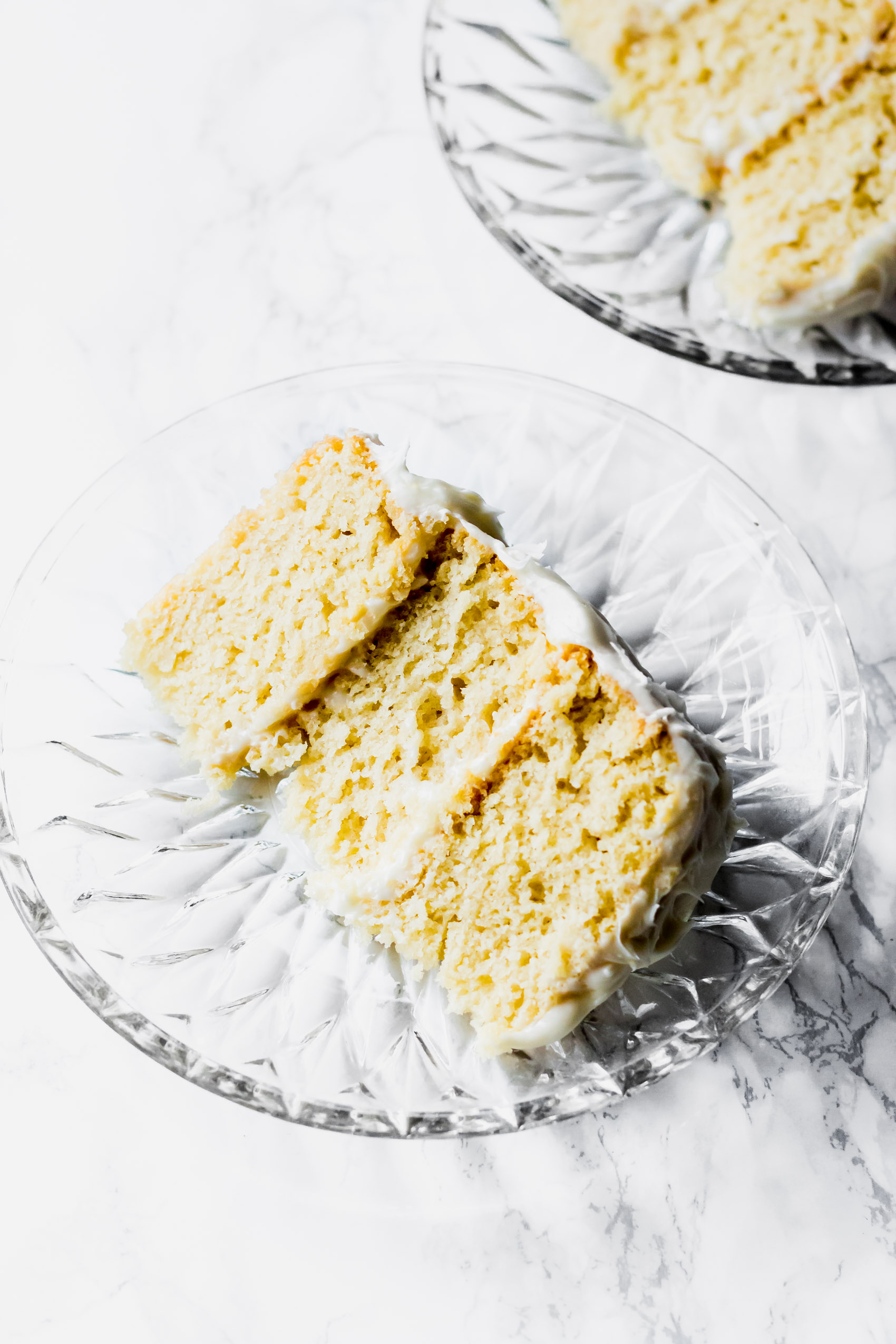 two slices of vegan vanilla cake served on small glass plates