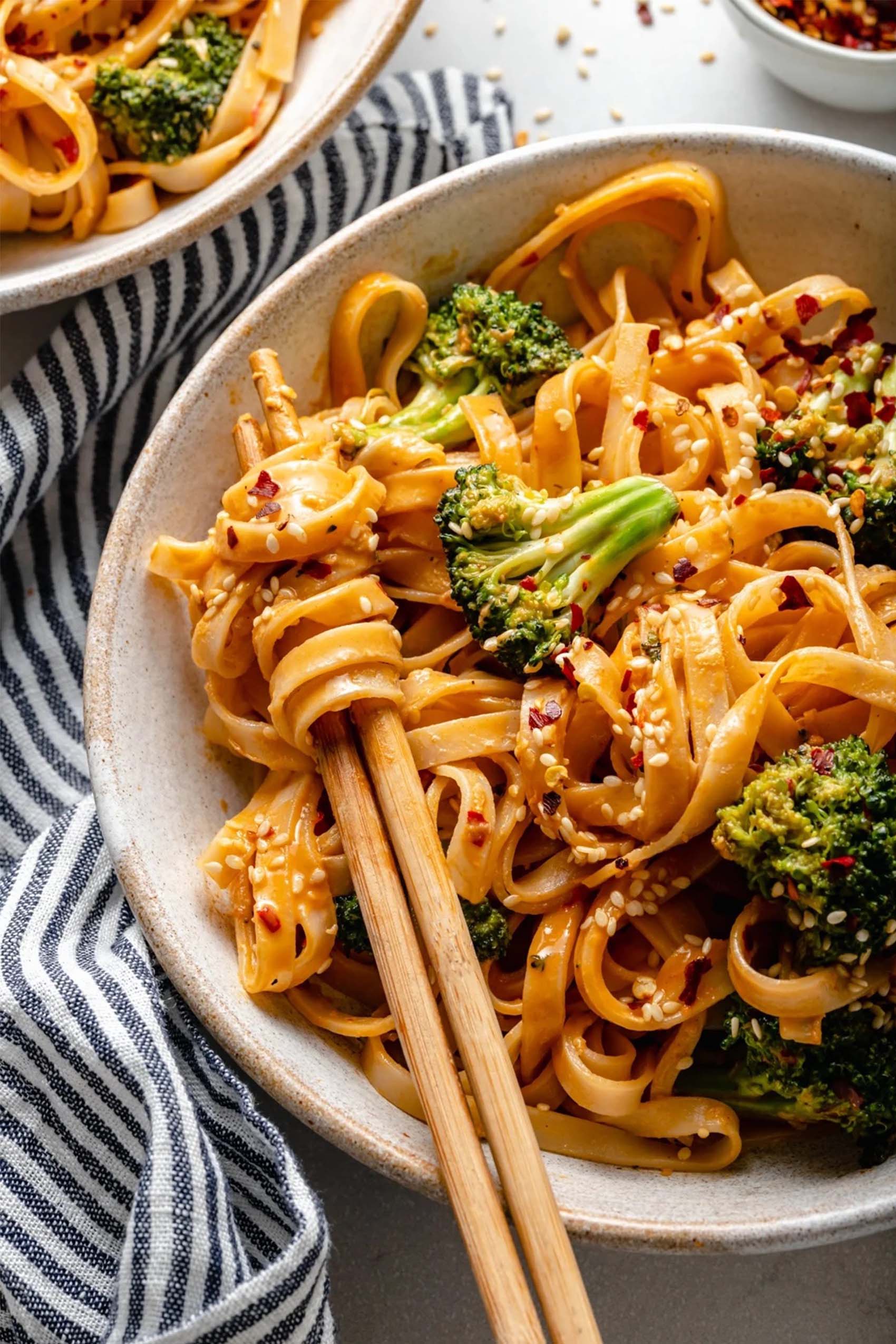 a bowl of vegan stir fried noodles served with broccoli