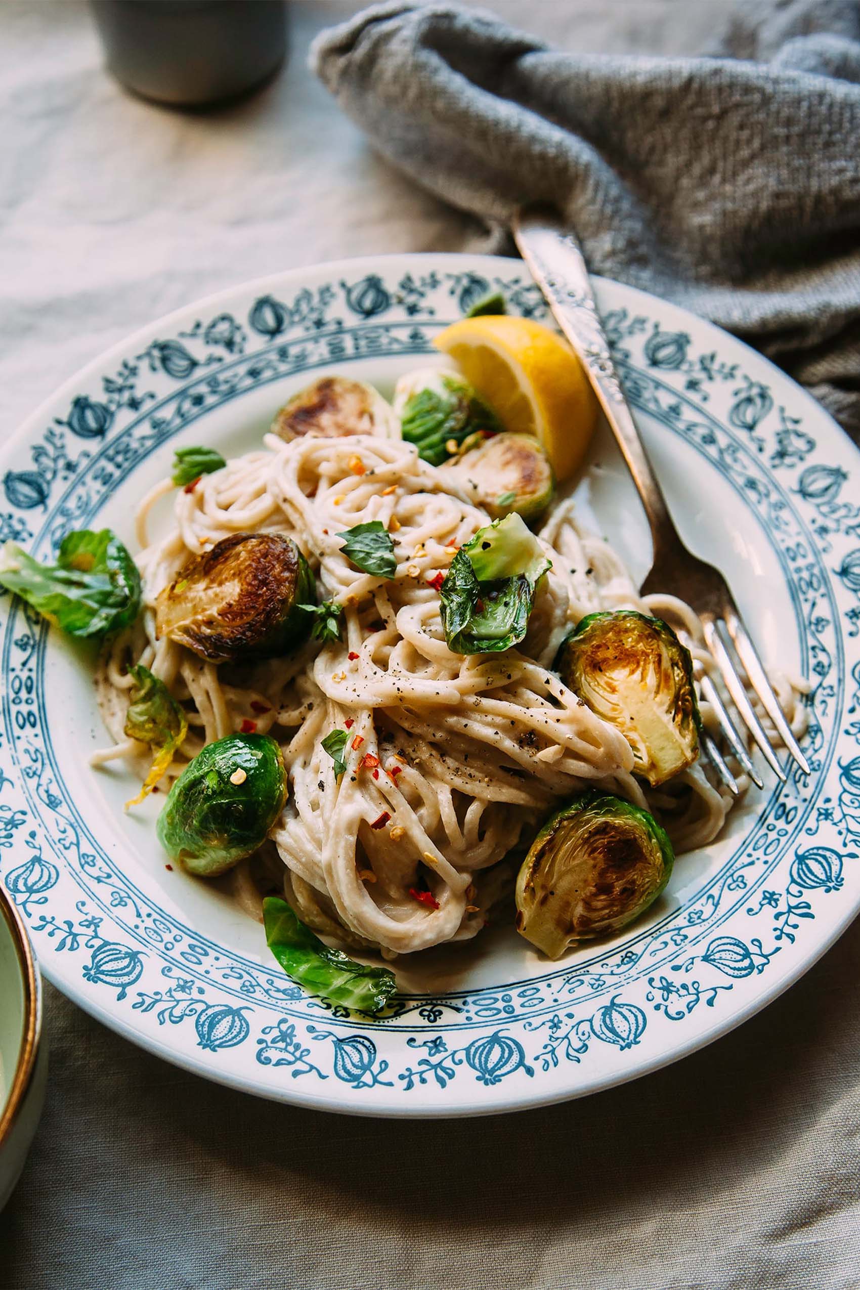 a plate of vegan pasta served with brussels sprouts