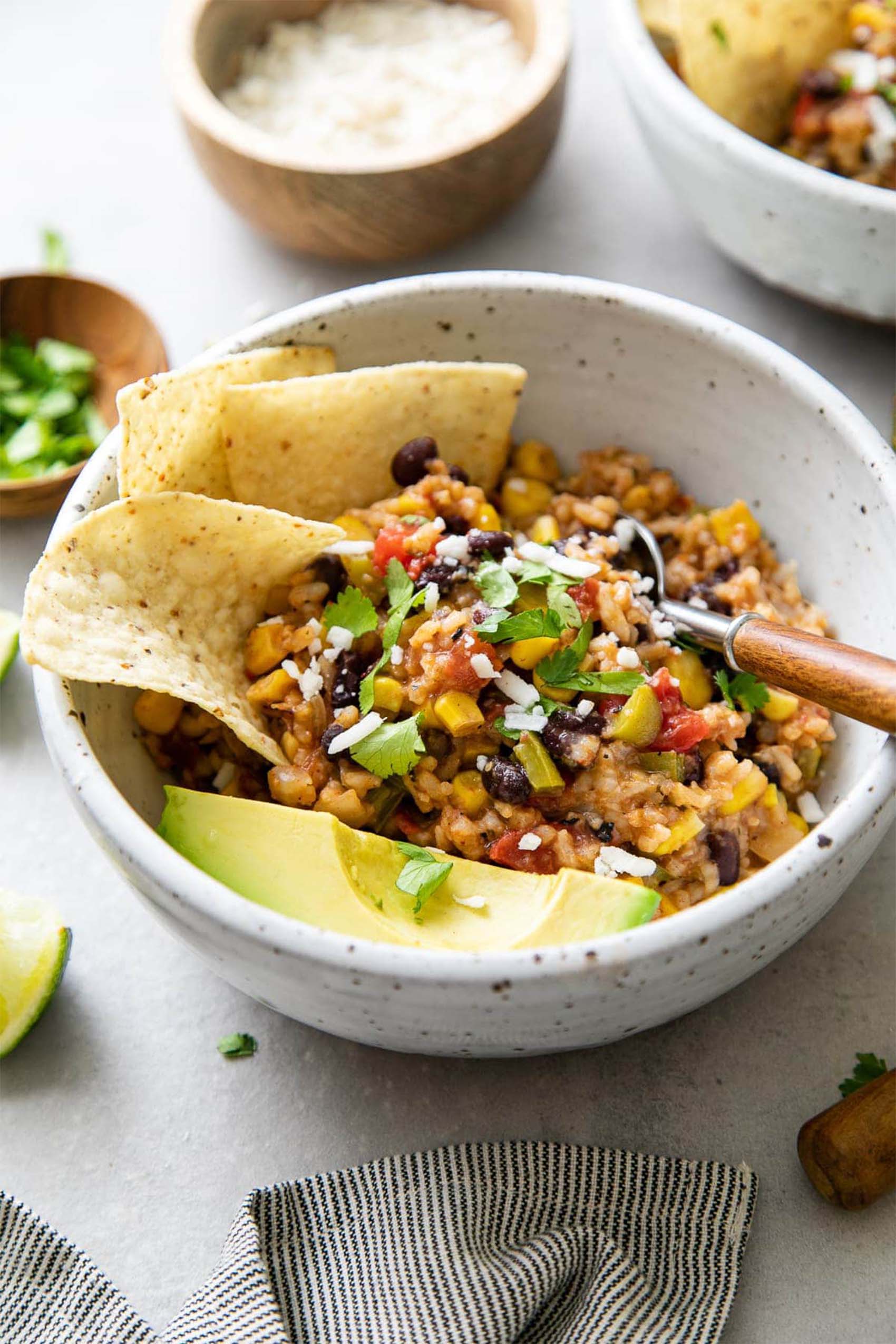 a bowl of vegan enchilada rice served with chips and avocado