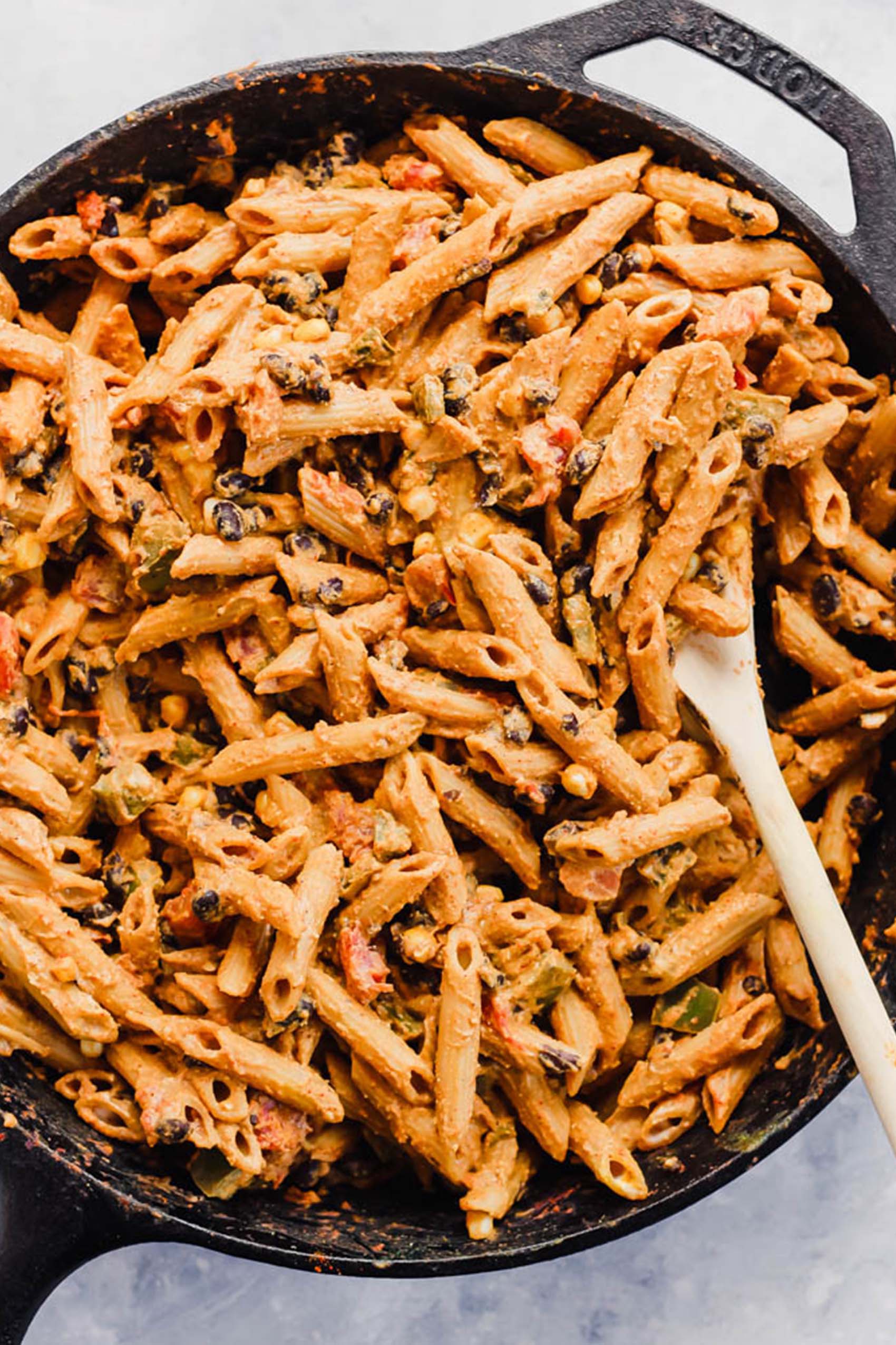 a spoon stirring a skillet of mexican pasta