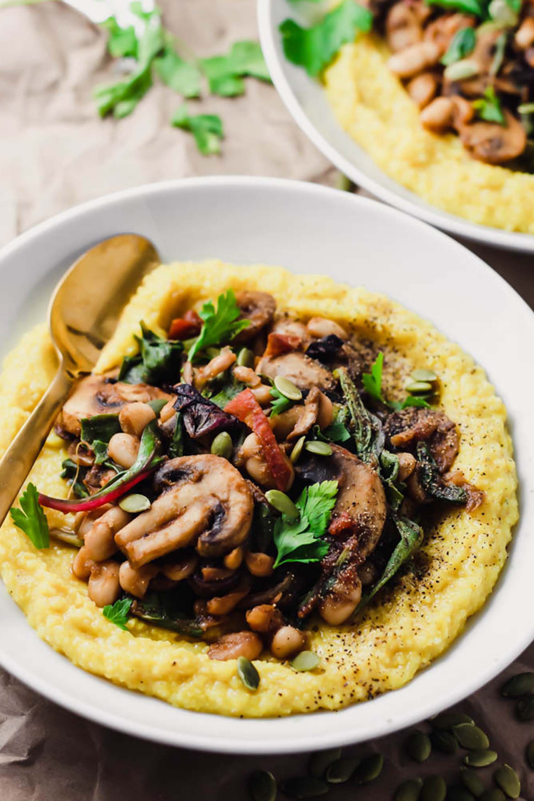 a bowl of polenta topped with sauteed vegetables