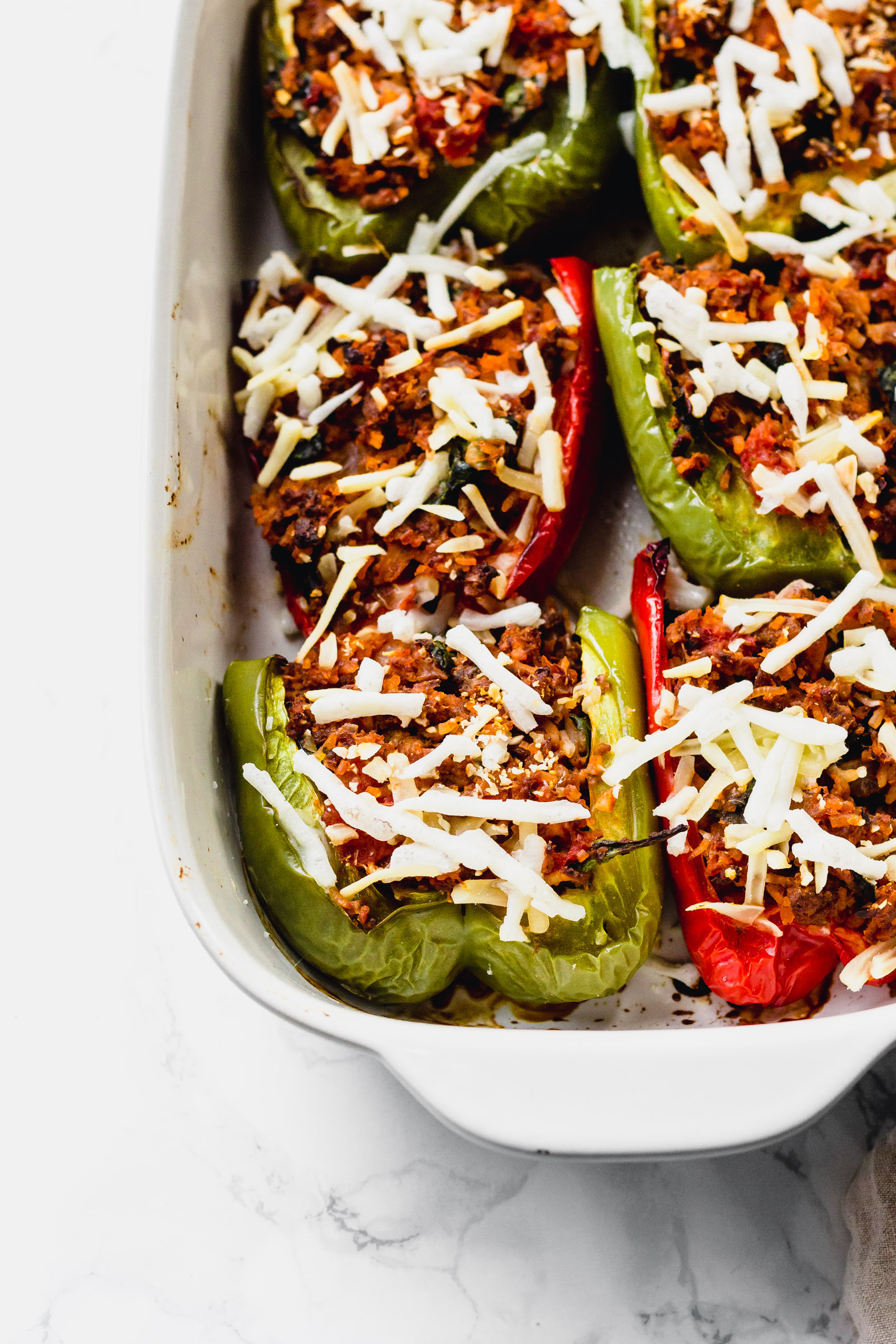 a batch of stuffed peppers topped with vegan cheese
