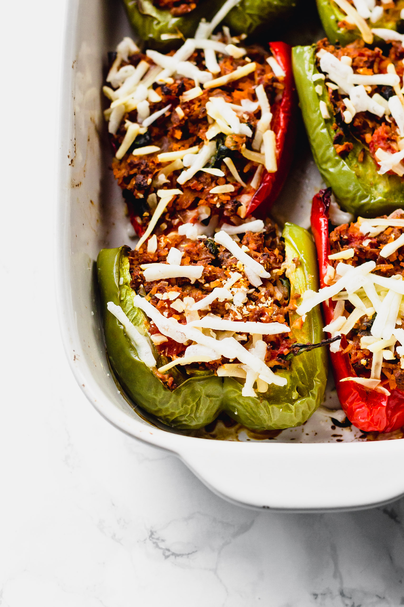 a close up of a white casserole dish holding a batch of stuffed peppers