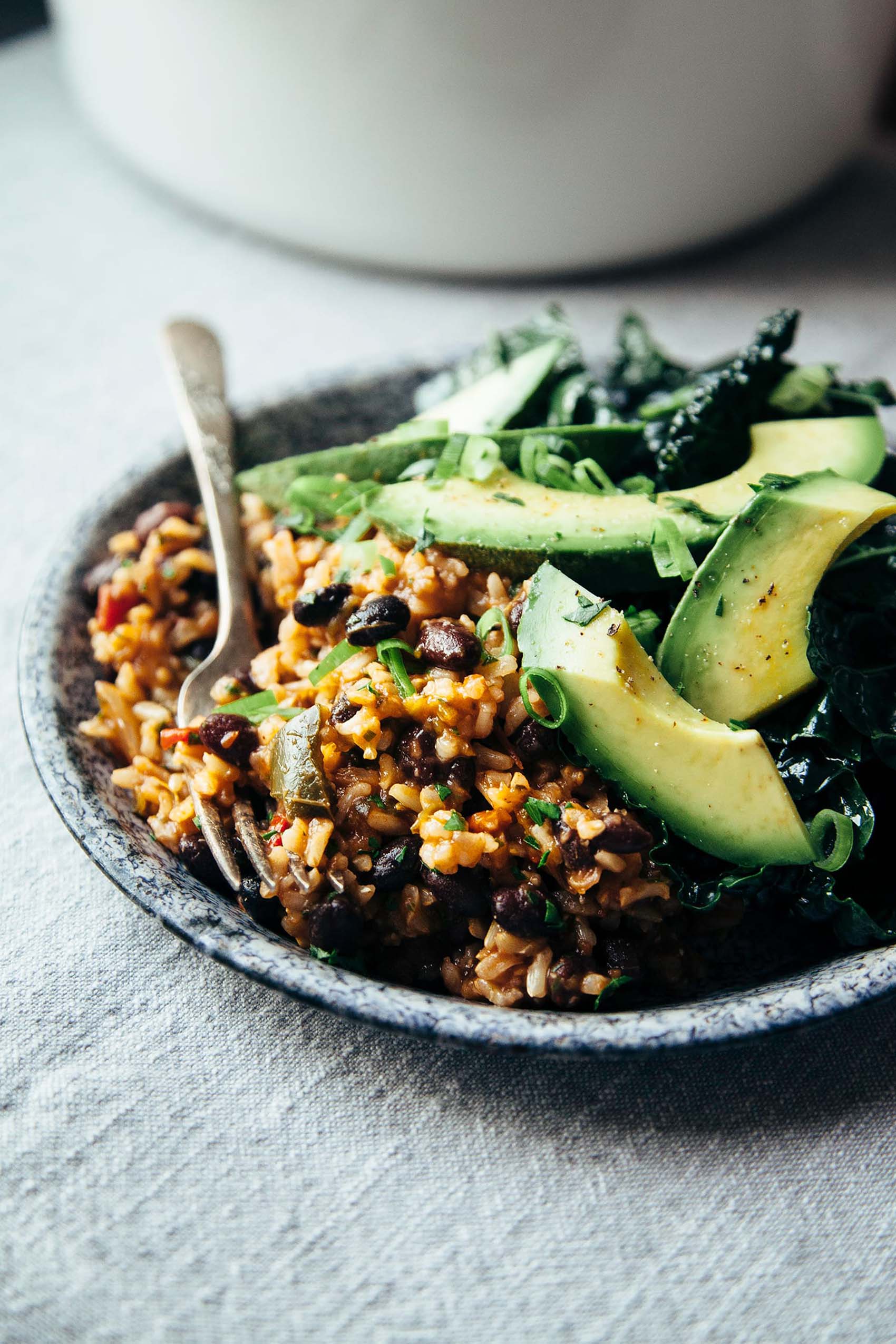 a plate of rice and beans topped with avocado slices