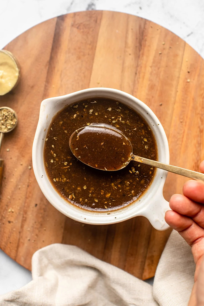 a bowl of balsamic dressing being served with a spoon