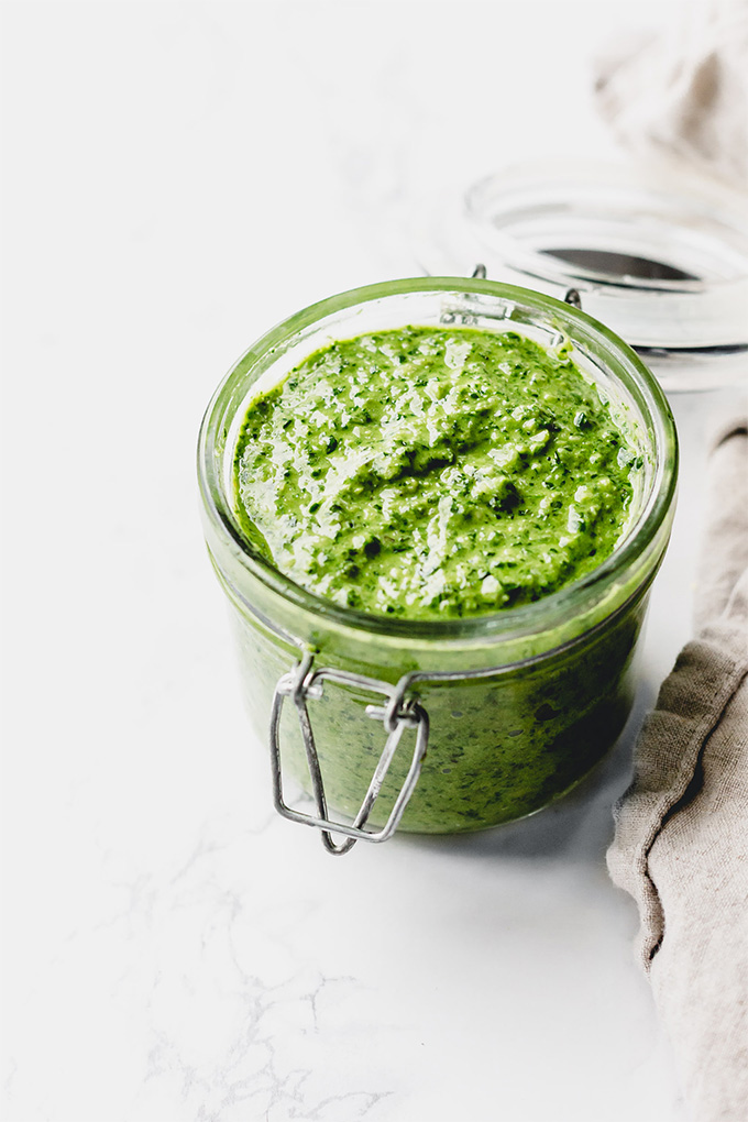 a flip top jar containing homemade pesto