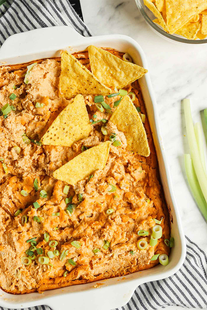 a dish of homemade vegan buffalo dip served with celery and chips