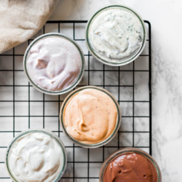 5 bowls of different flavors of vegan cream cheese