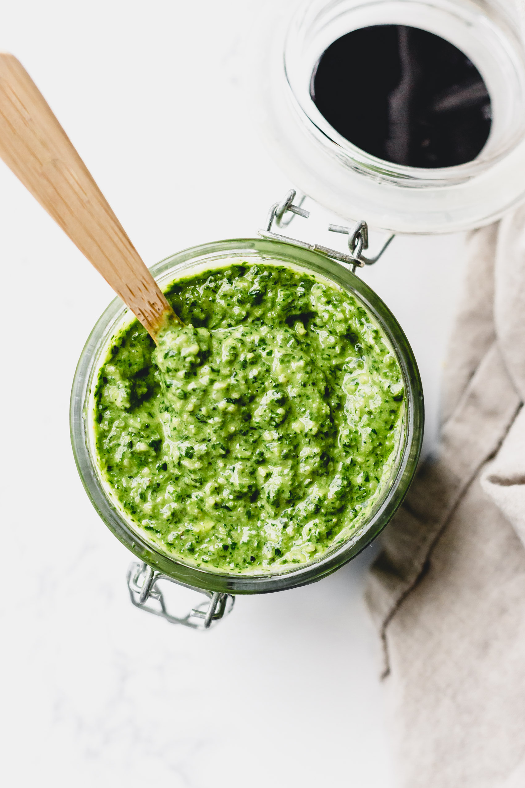 a spoon in a jar of pesto