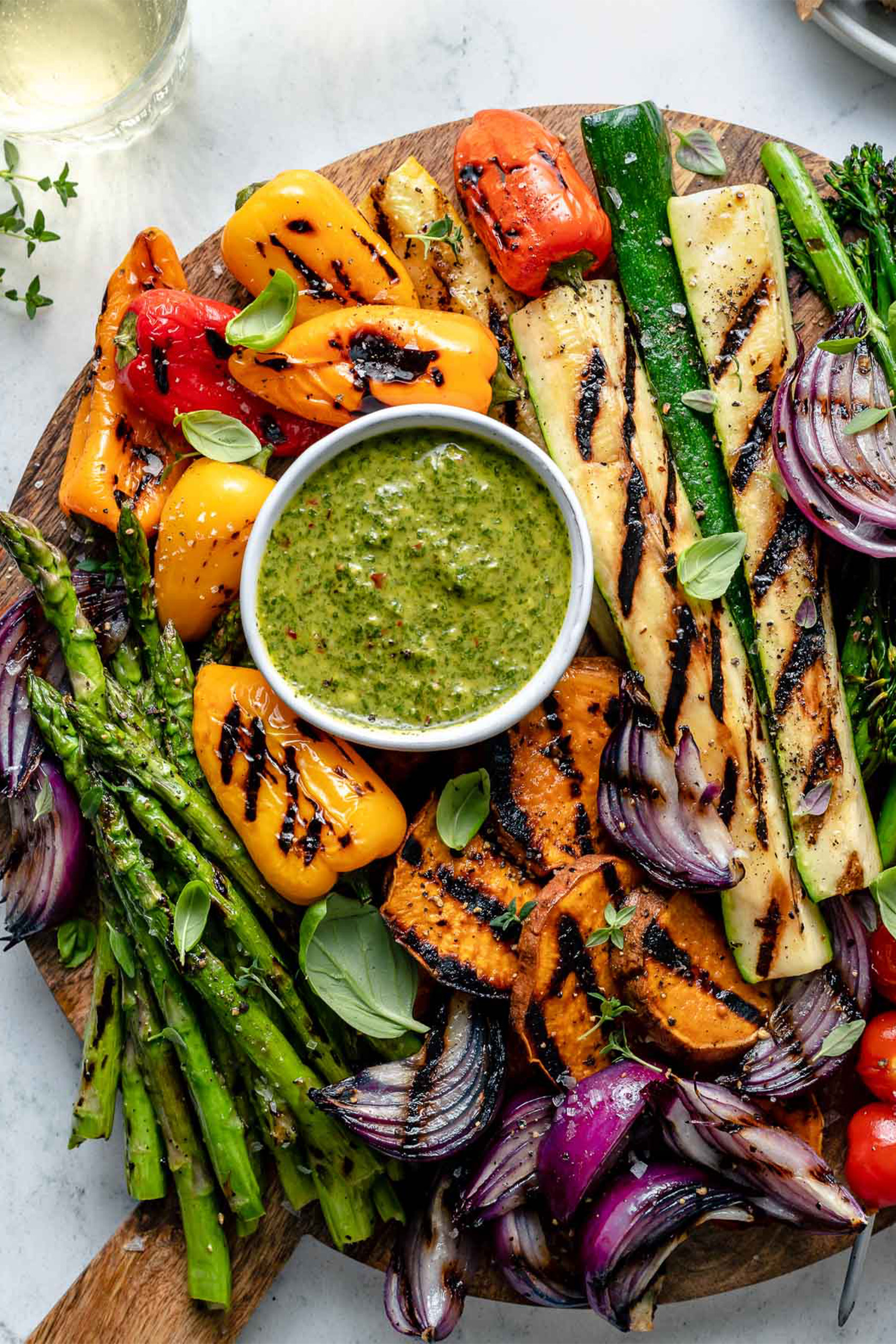a platter of grilled vegetables served with homemade chimichurri sauce