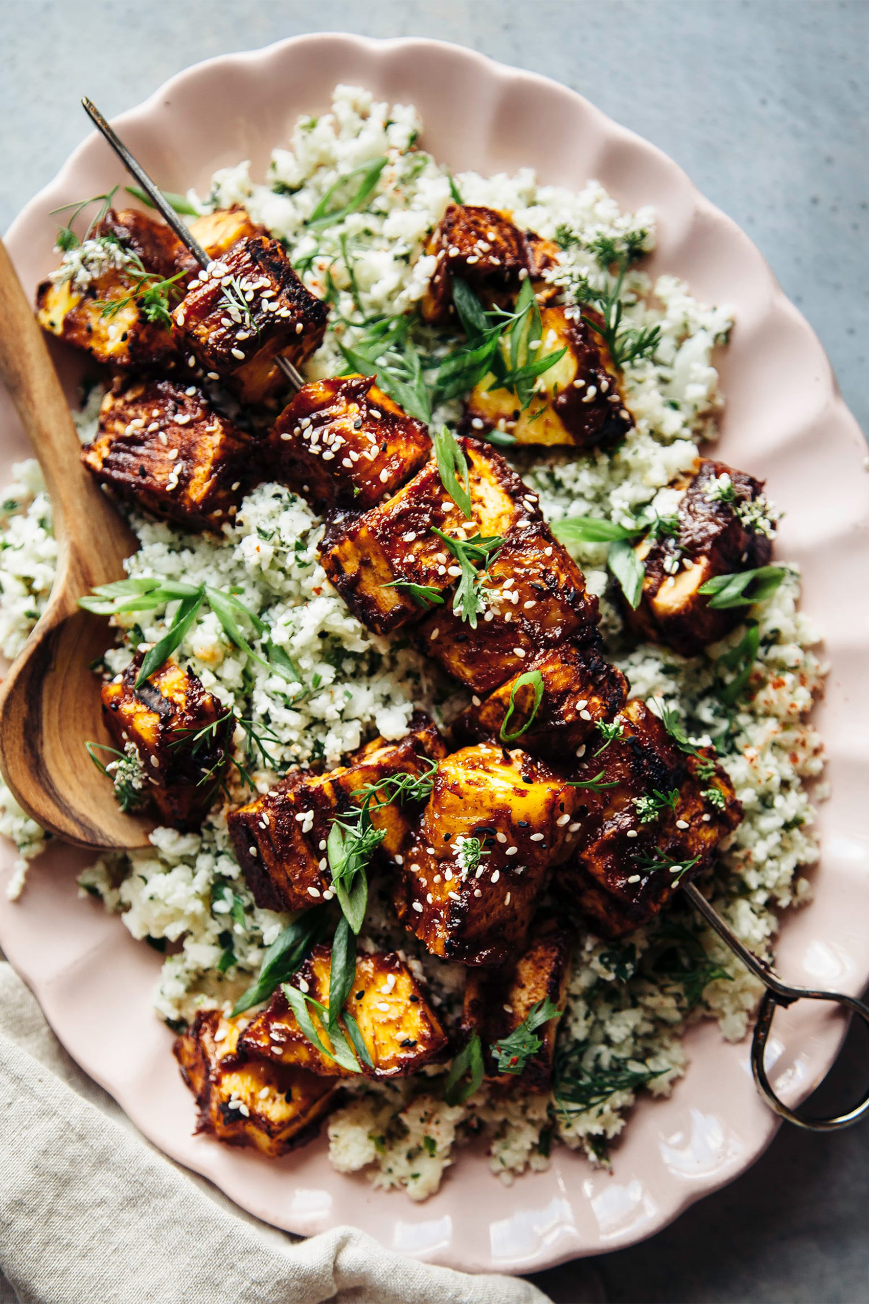 a dish of grilled tofu served over cauliflower rice