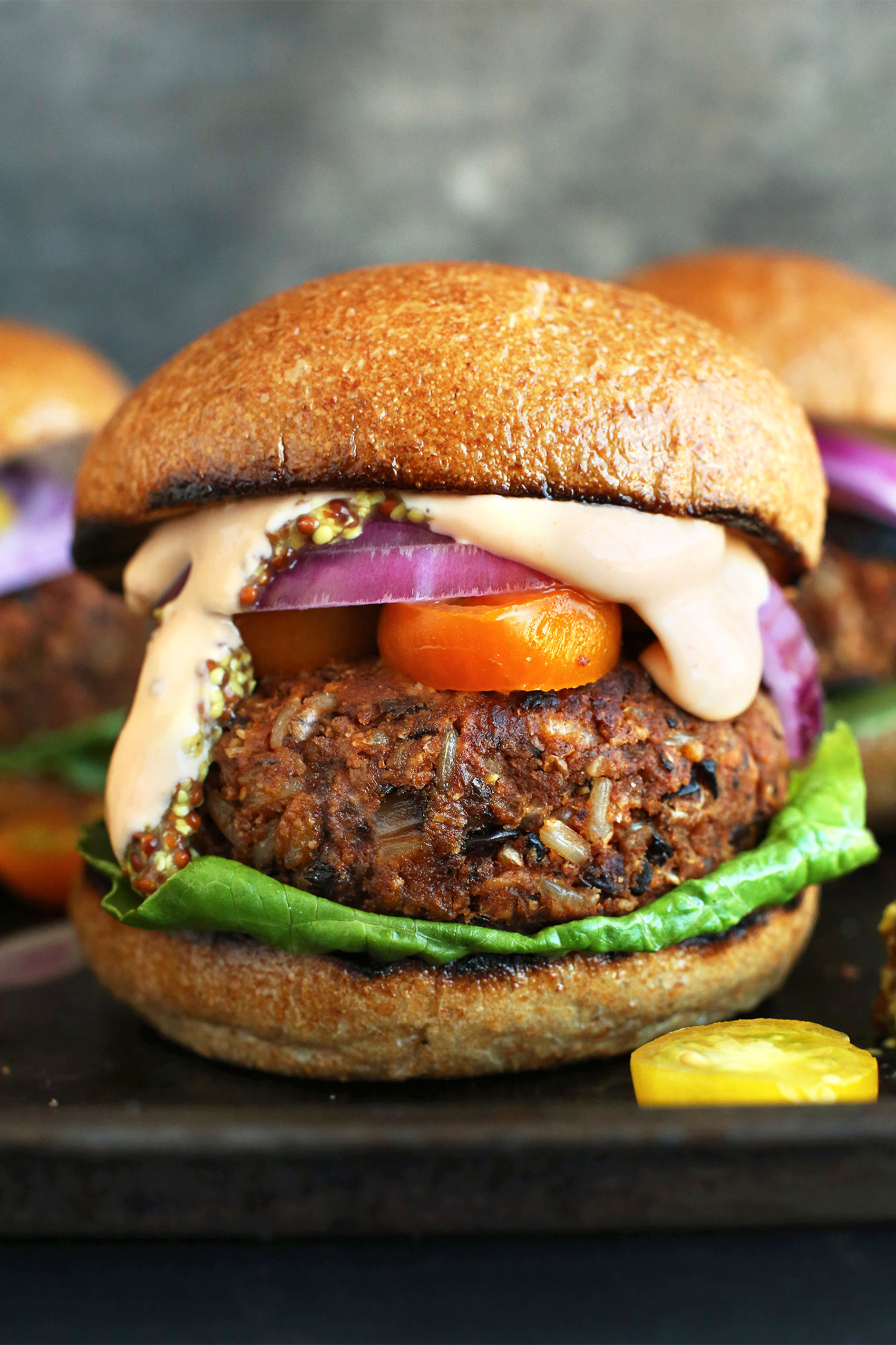 a bean and rice veggie burger topped with a special sauce, red onion, tomato and lettuce