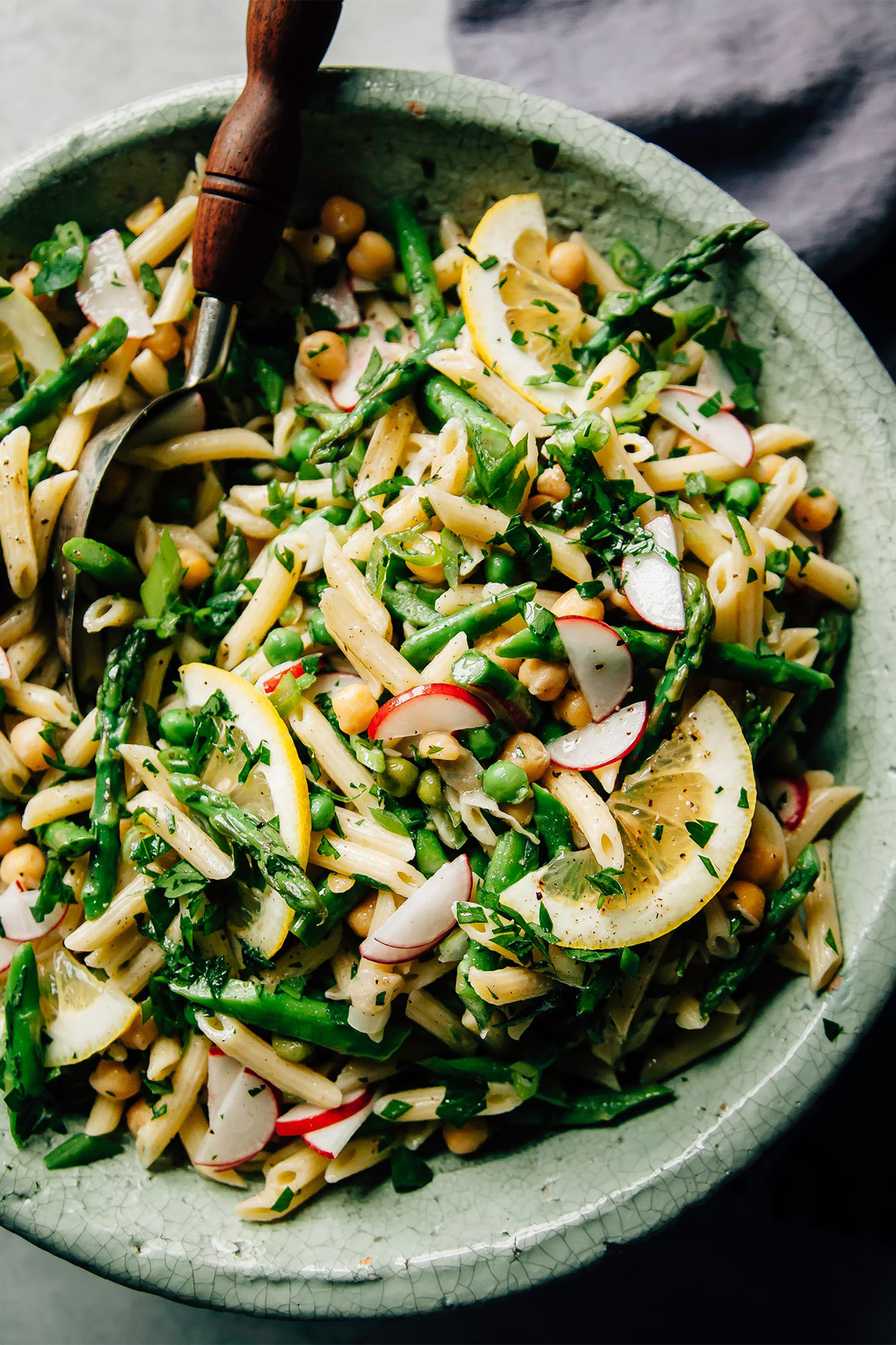a bowl of pasta salad with lots of mixed vegetables and herbs