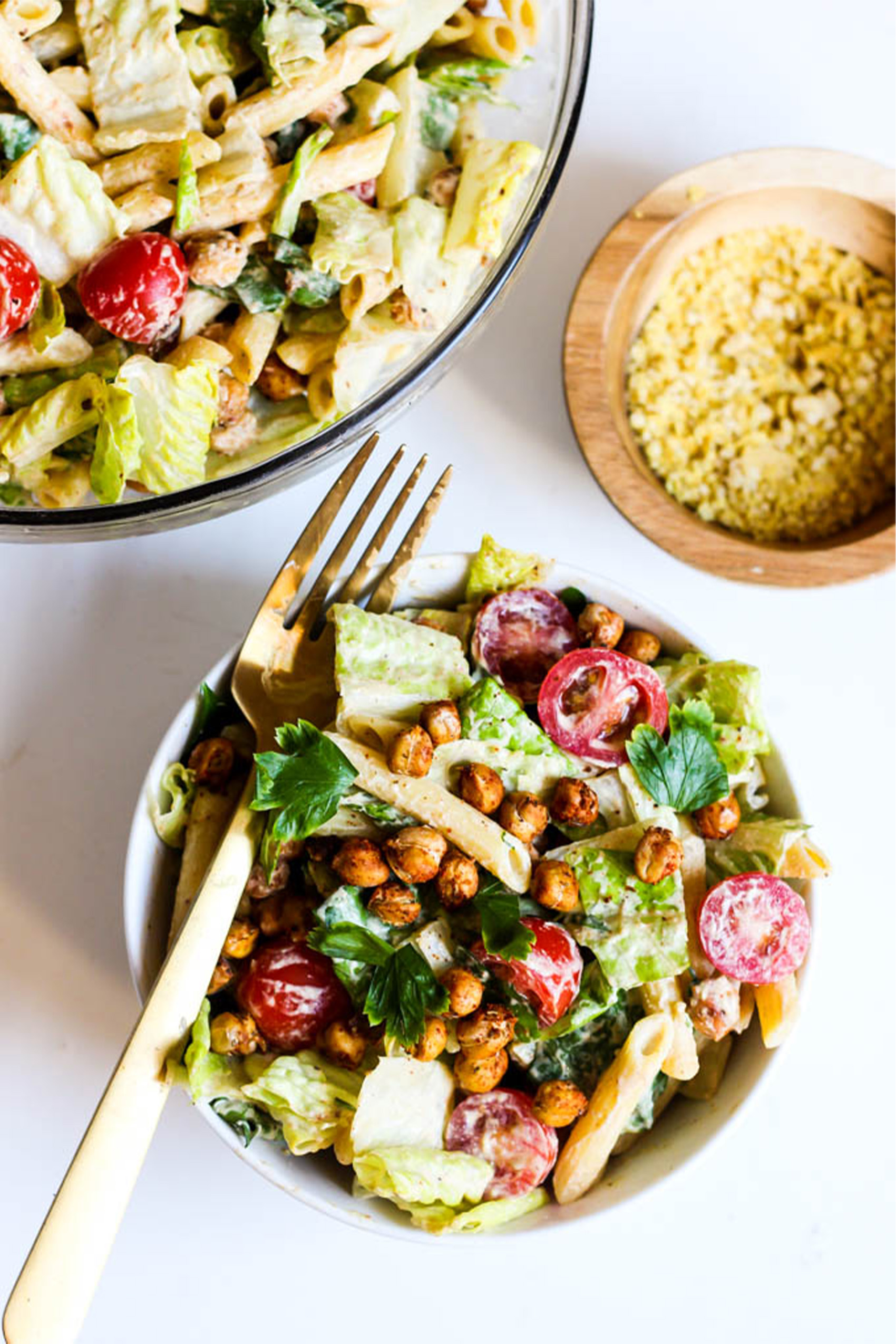 a bowl of caesar salad topped with roasted chickpeas