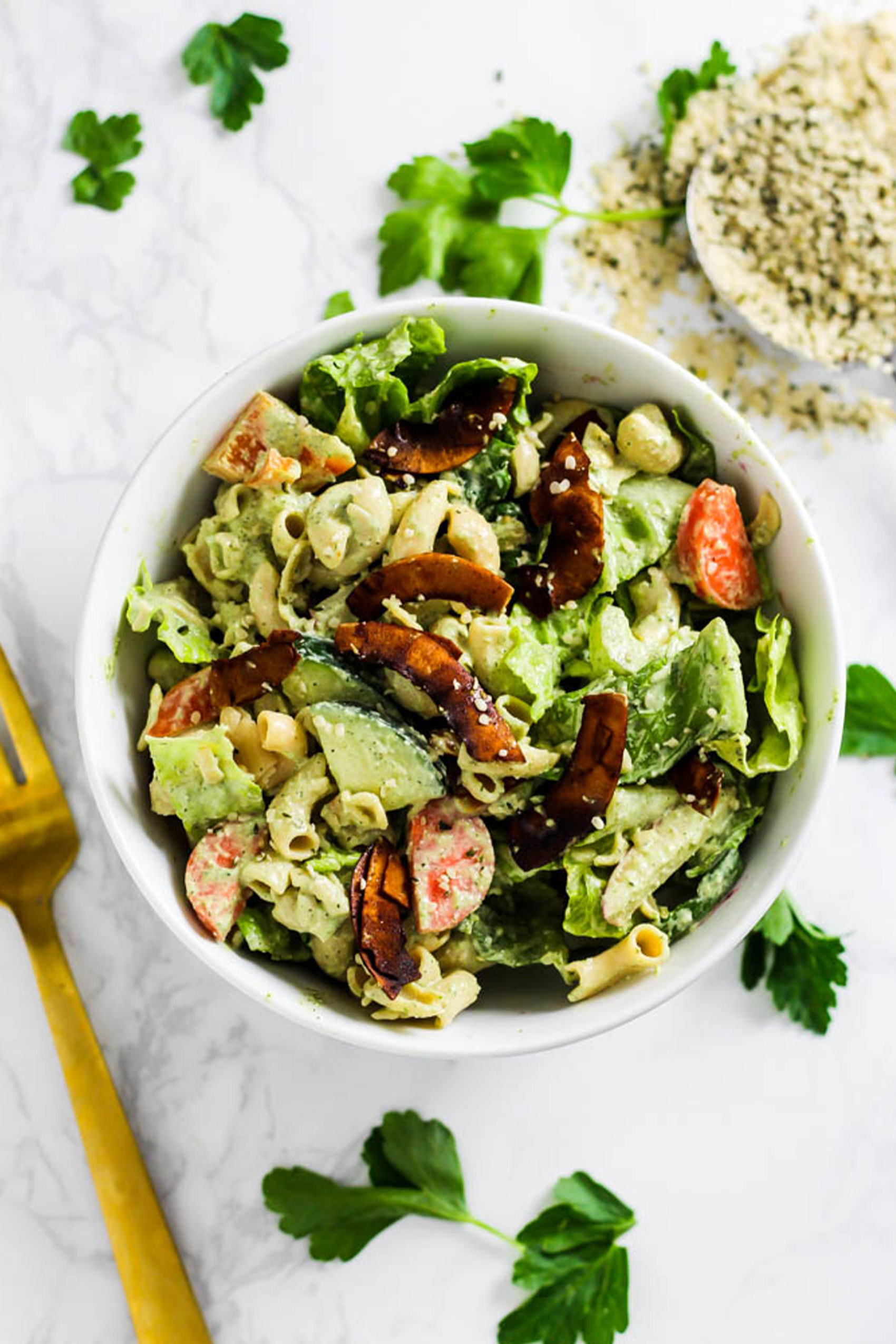 a vegan pasta salad topped with vegan coconut bacon