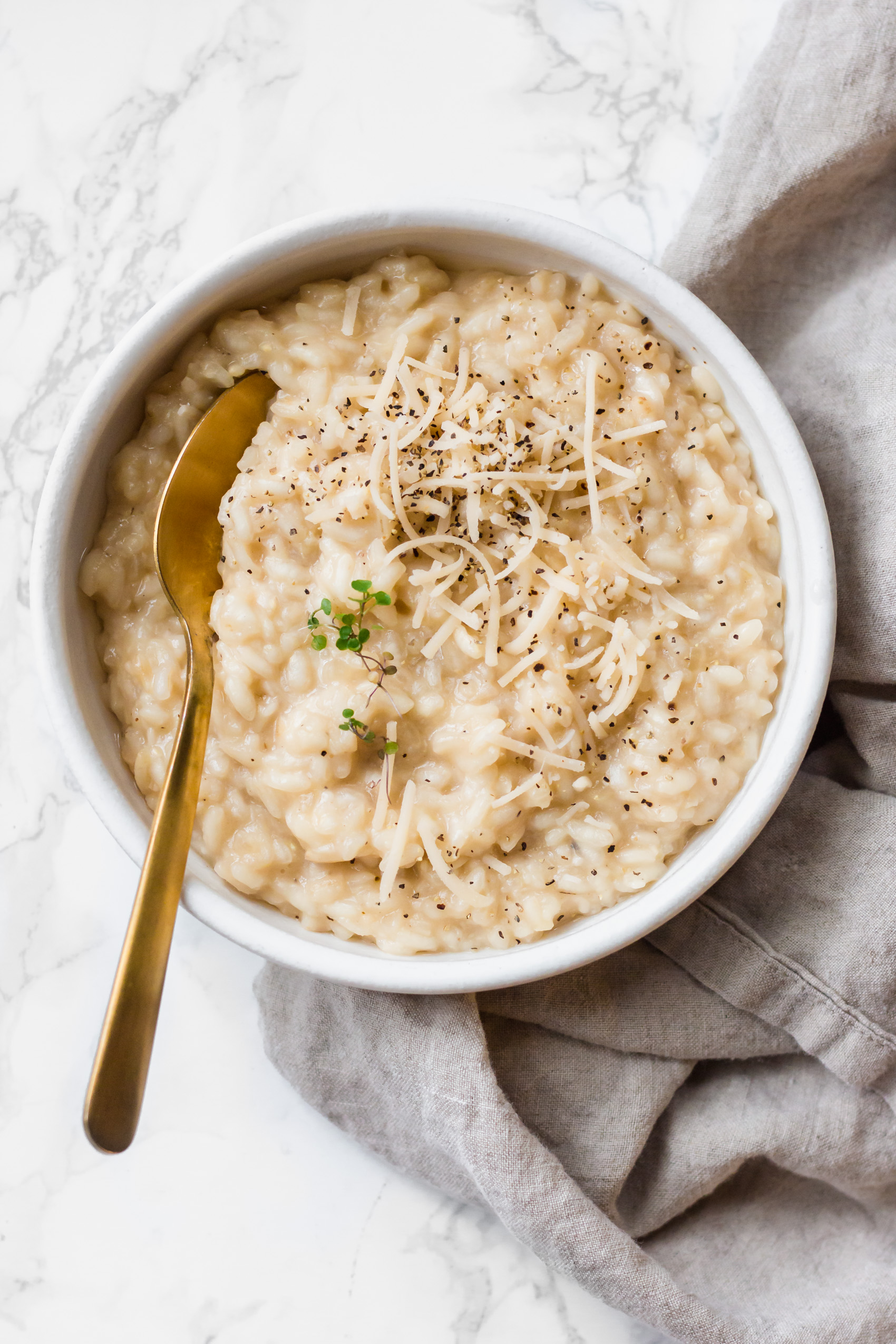 a spoon resting in a bowl of vegan risotto