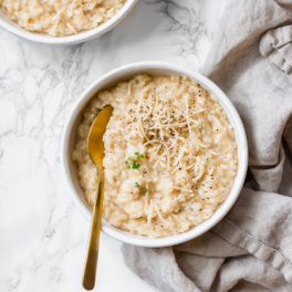 a spoon digging into a bowl of risotto