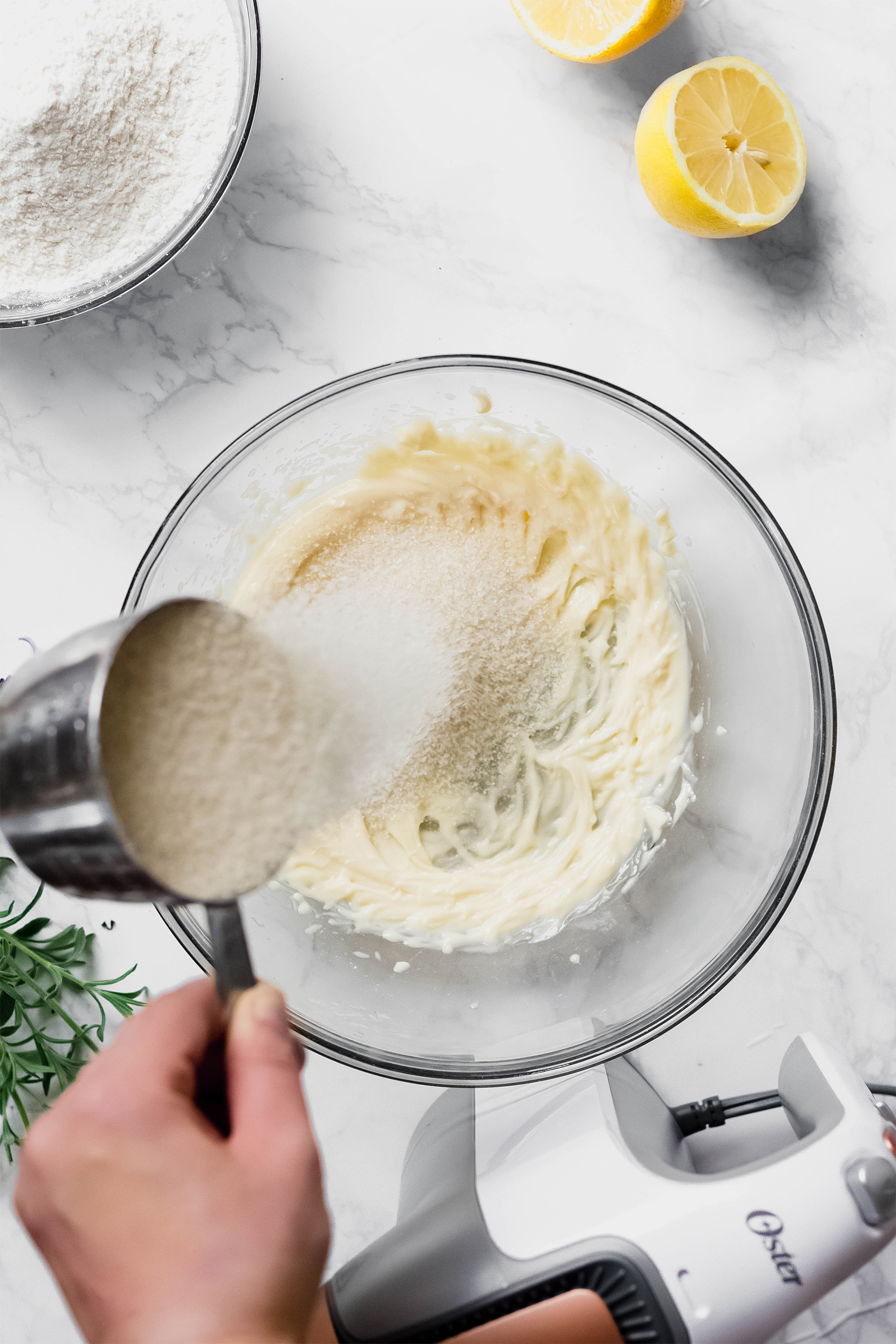 a cup of sugar being mixed into a cookie dough