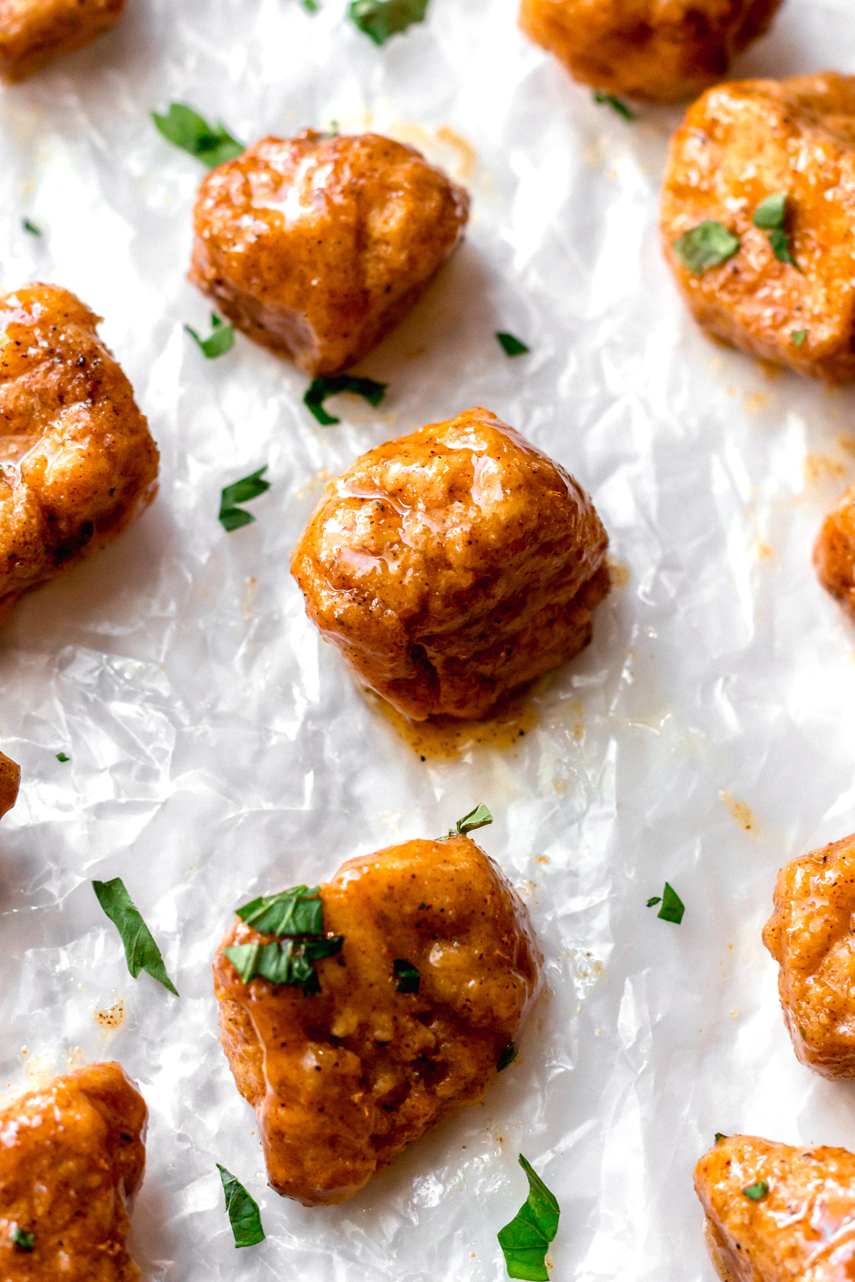 vegan hot honey chicken nuggets resting on a sheet tray covered in parchment paper