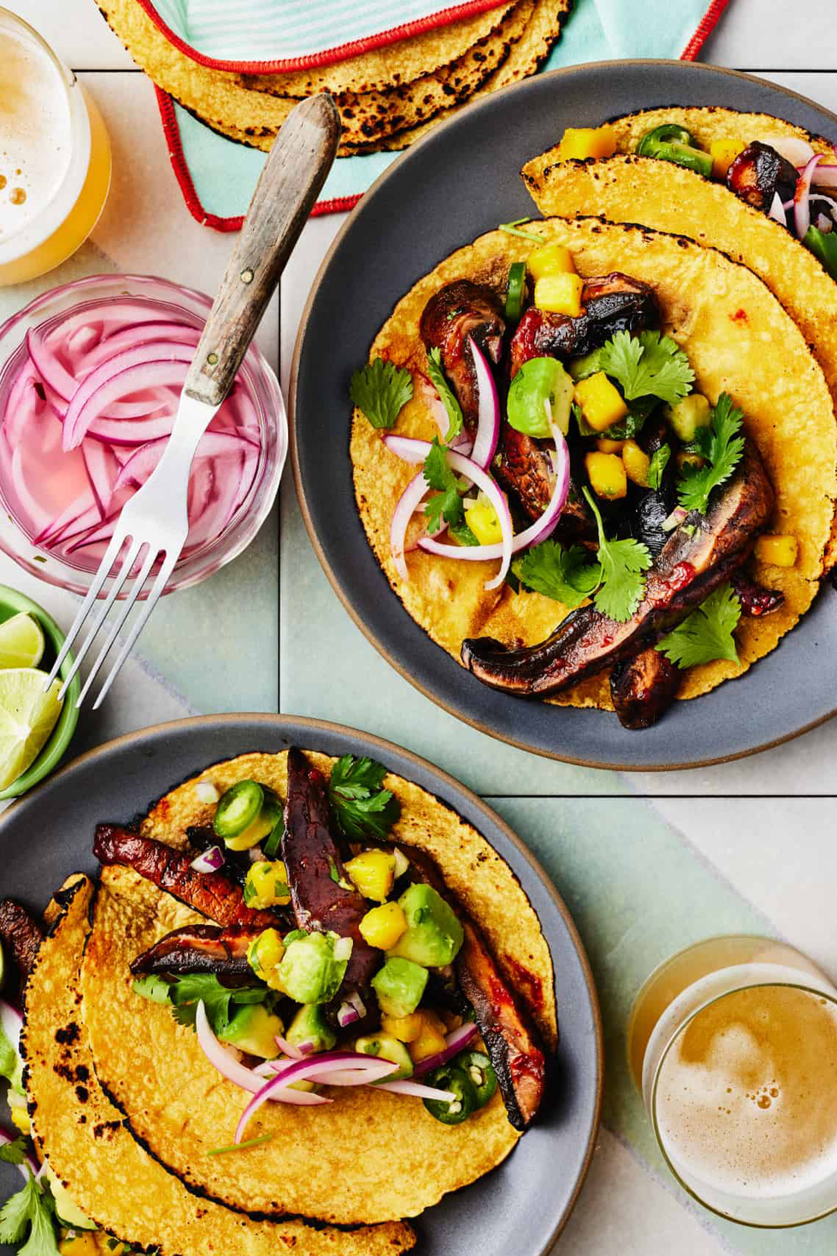 a batch of vegan mushroom tacos served with avocado and pickled onions