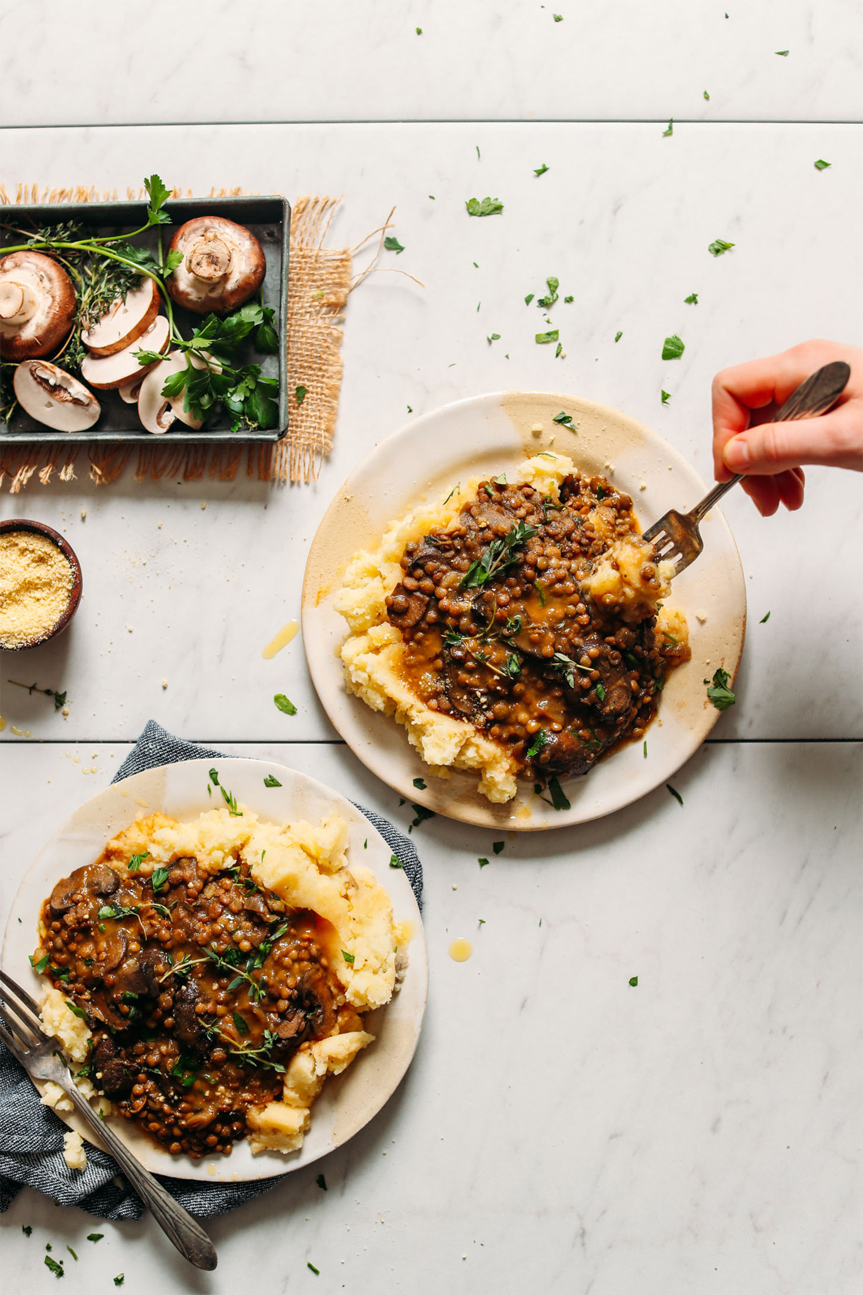 two plates of mashed potatoes topped with a mushroom and lentil gravy