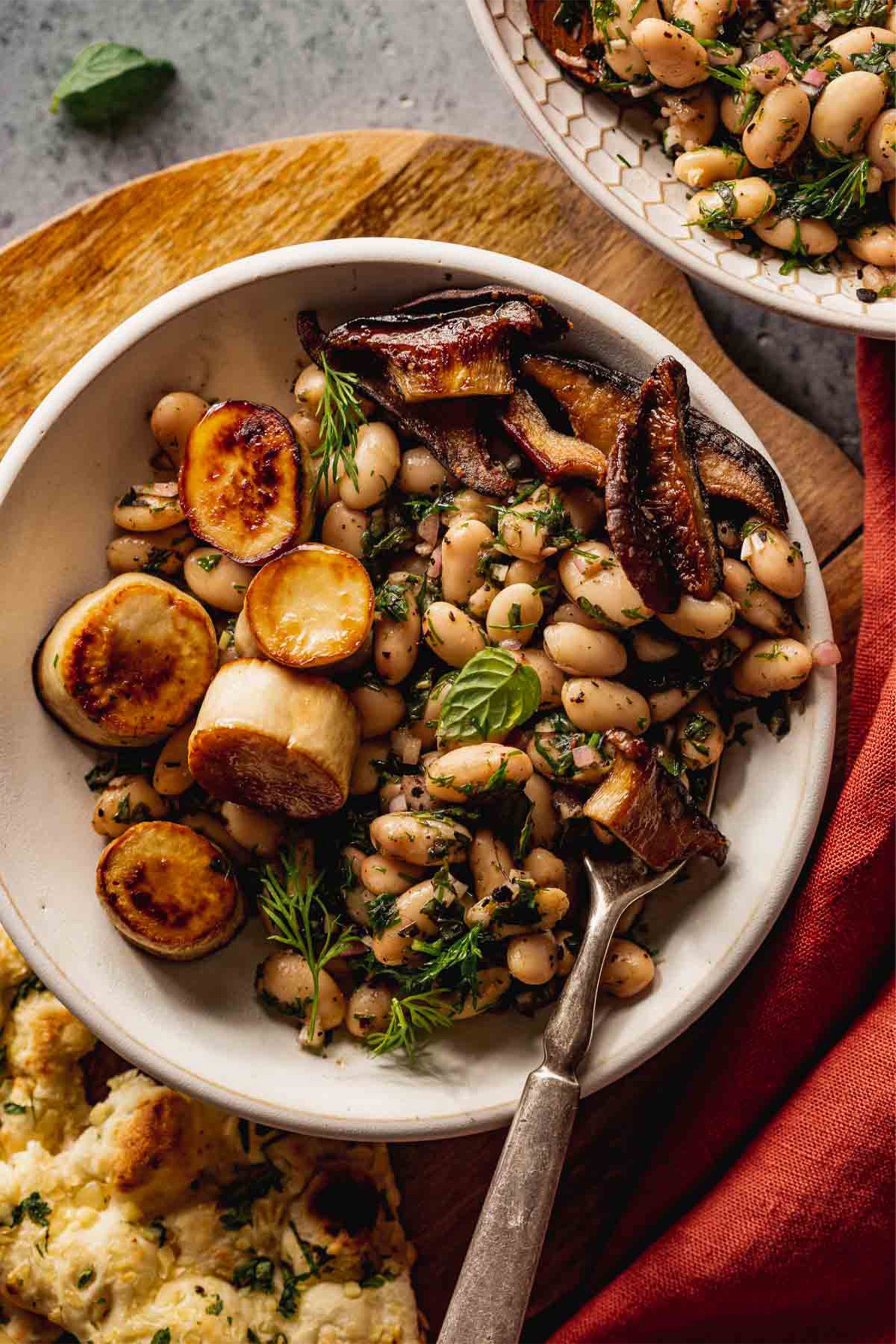 a plate of vegan scallops made with trumpet mushrooms served with white beans