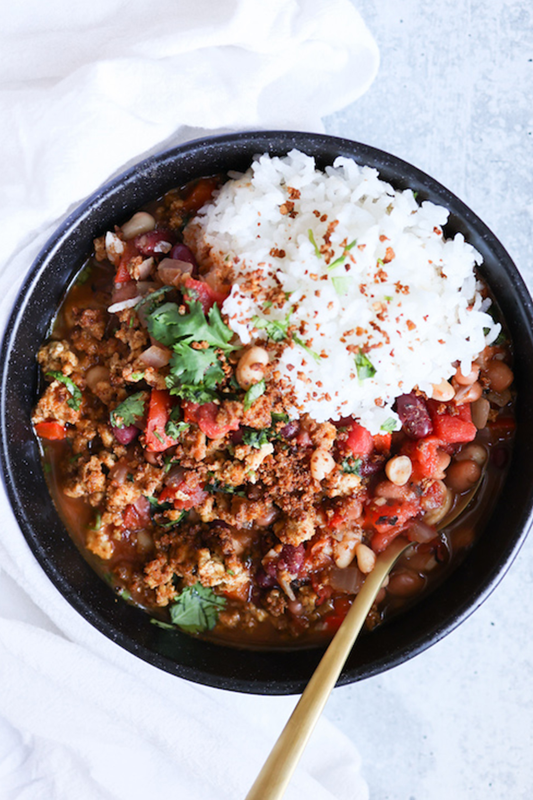 a bowl of vegan chili served with a scoop of white rice