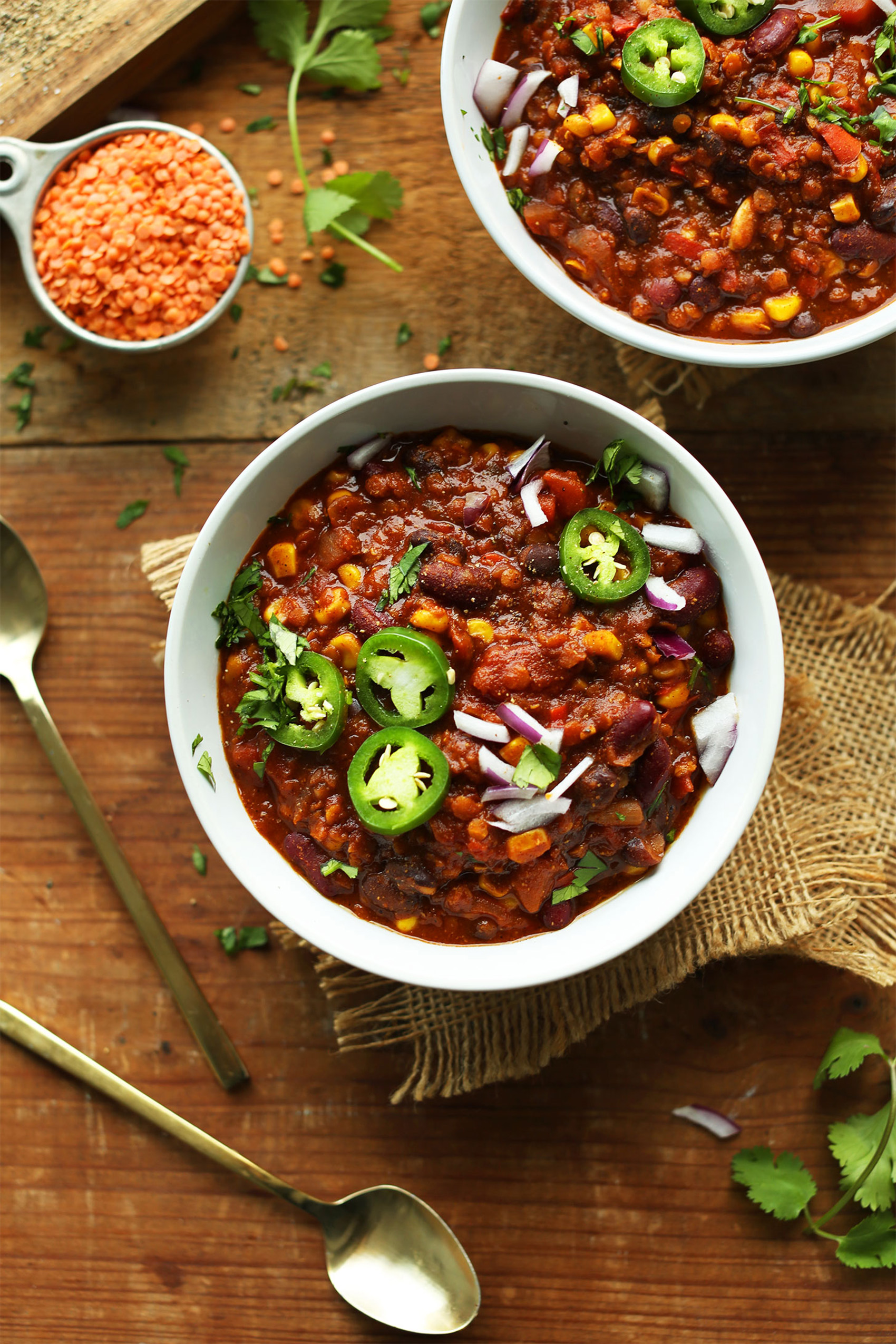two bowls of vegetarian chili topped with sliced jalapenos