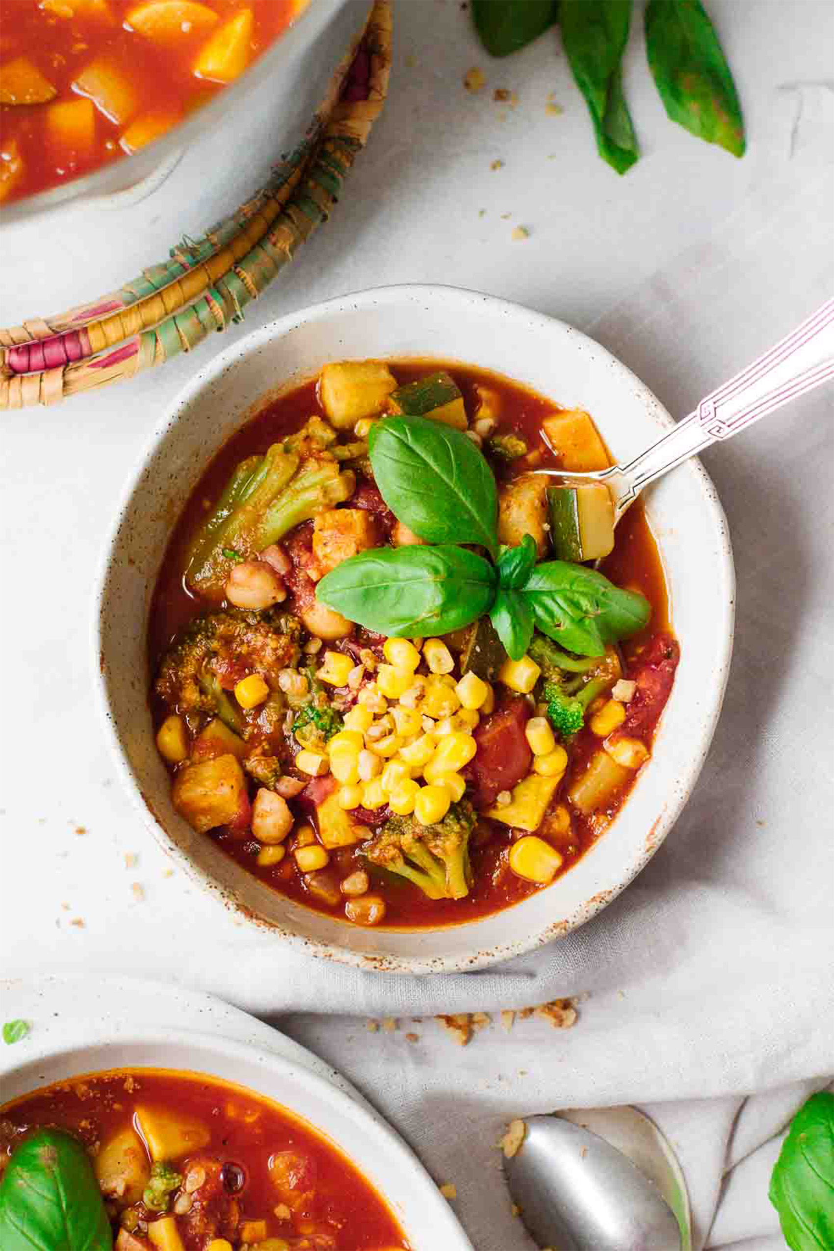 a bowl of corn and bean chili topped with basil