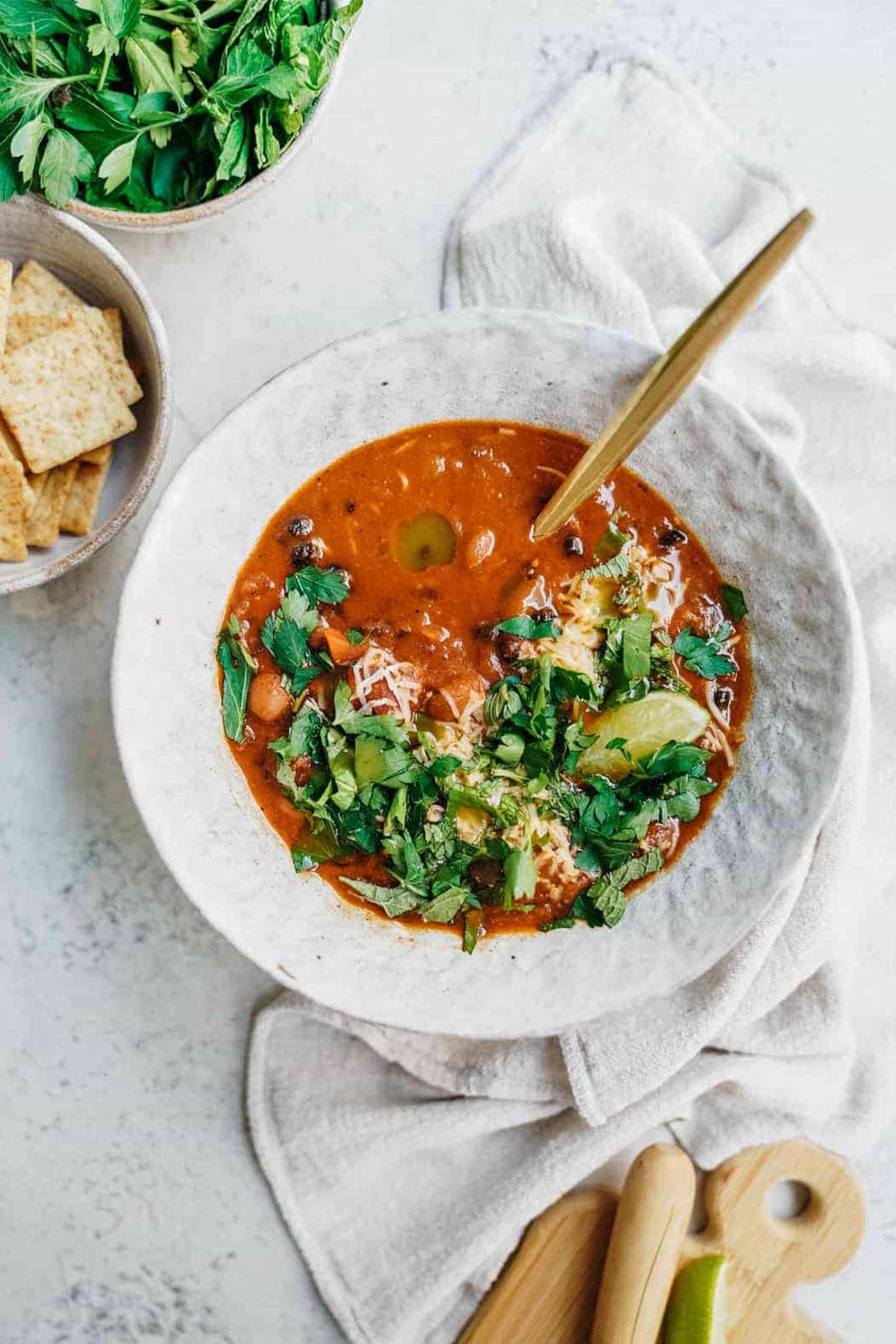 a bowl of vegetarian chili topped with chopped herbs