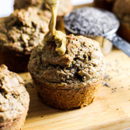 a banana almond butter muffin being drizzled with almond butter