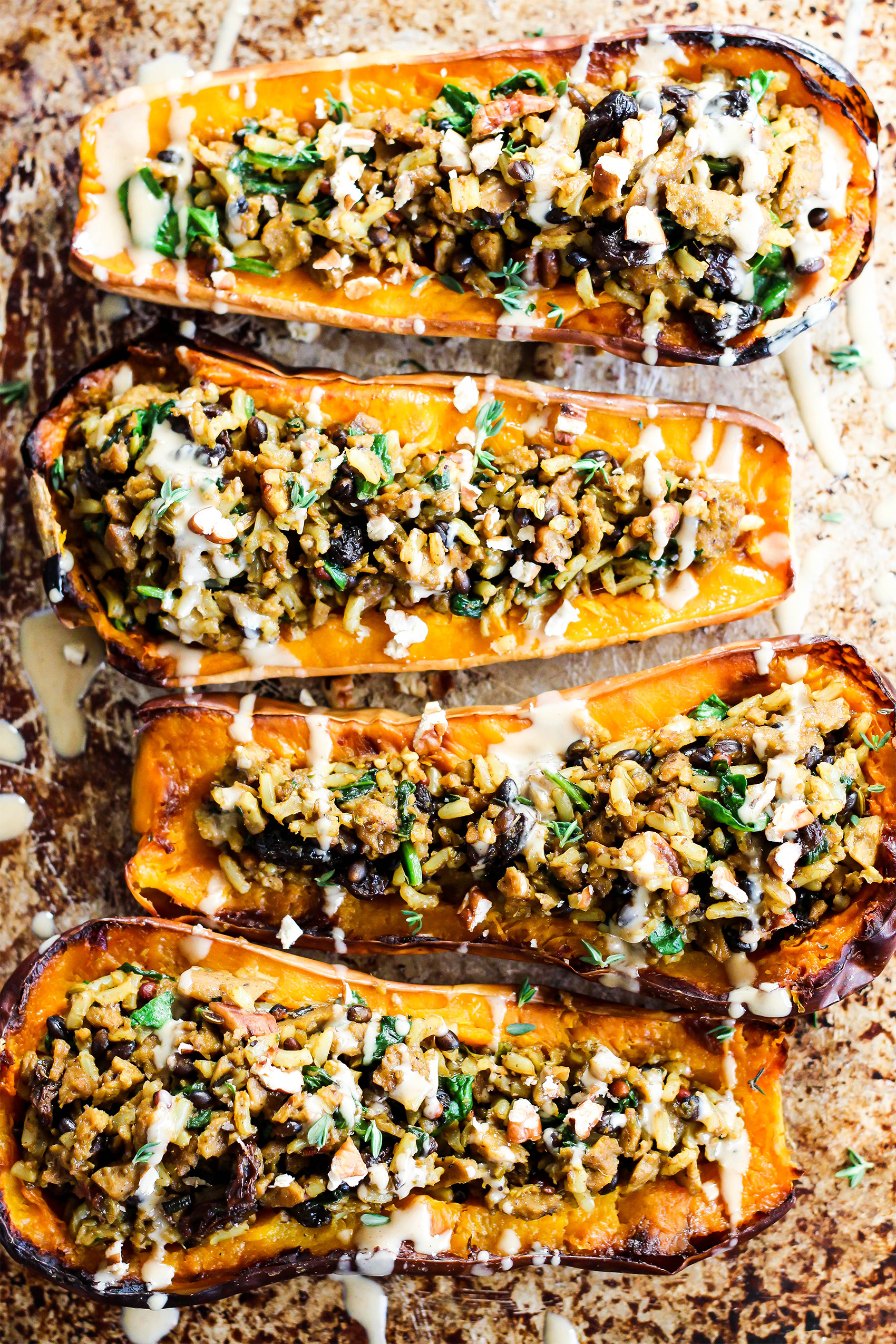 a sheet tray with halved butternut squashes that have been filled with vegan crumbles