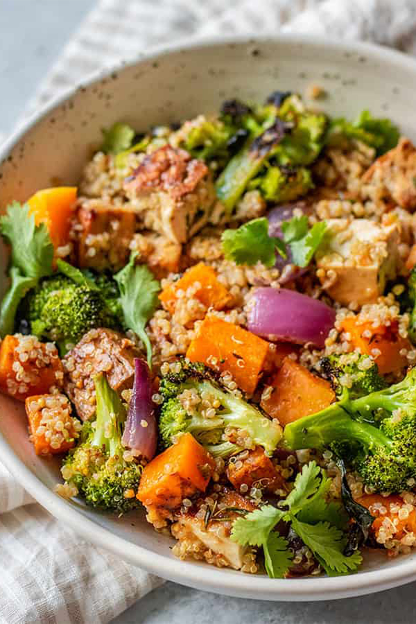a bowl of quinoa served with butternut squash and broccoli