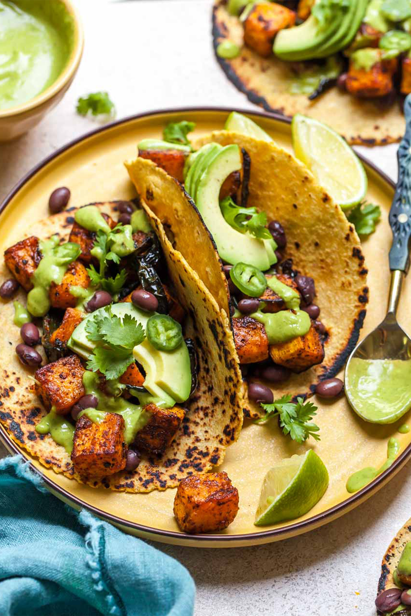 two butternut squash tacos served with avocado