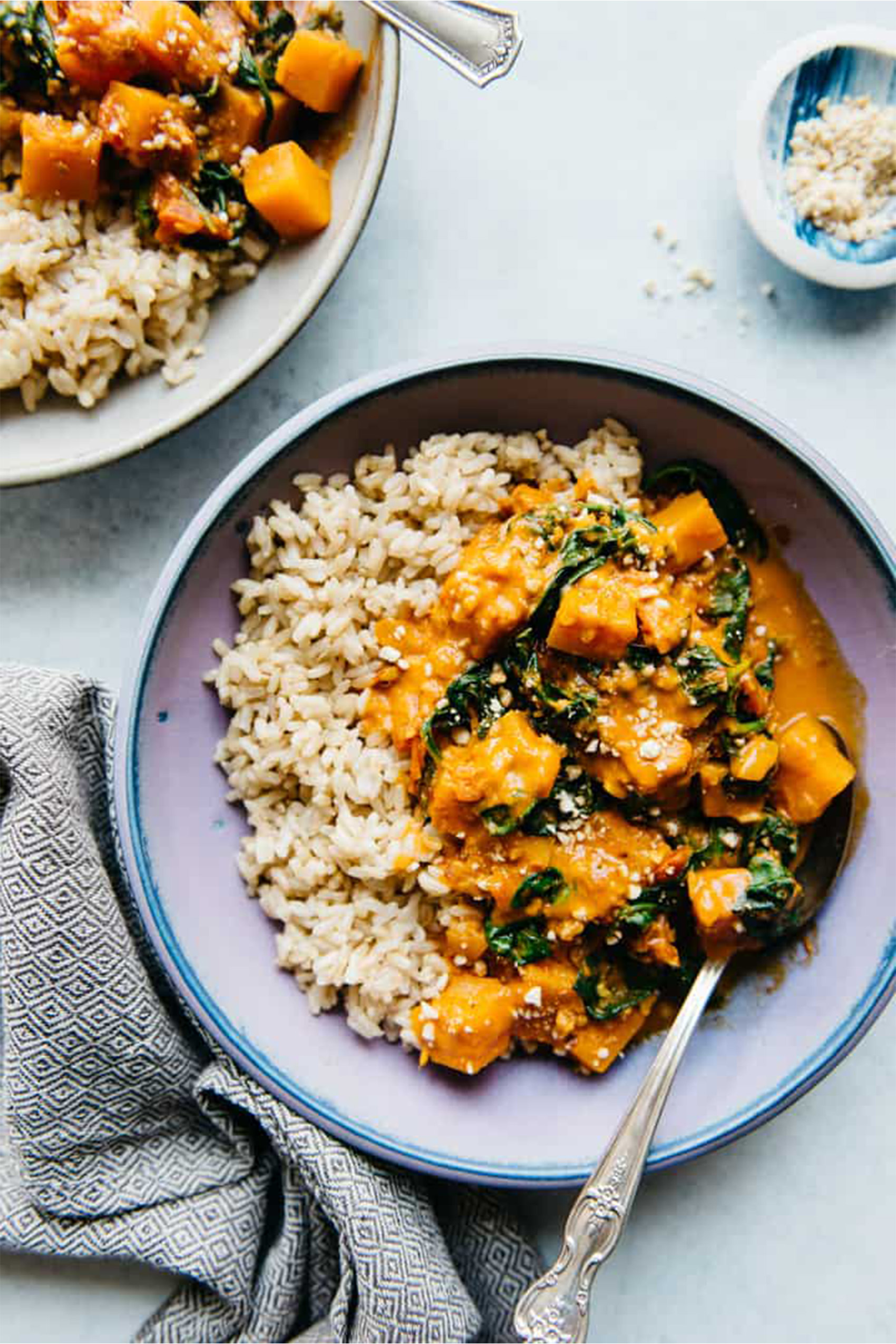 a vegan butternut squash and spinach curry served with brown rice