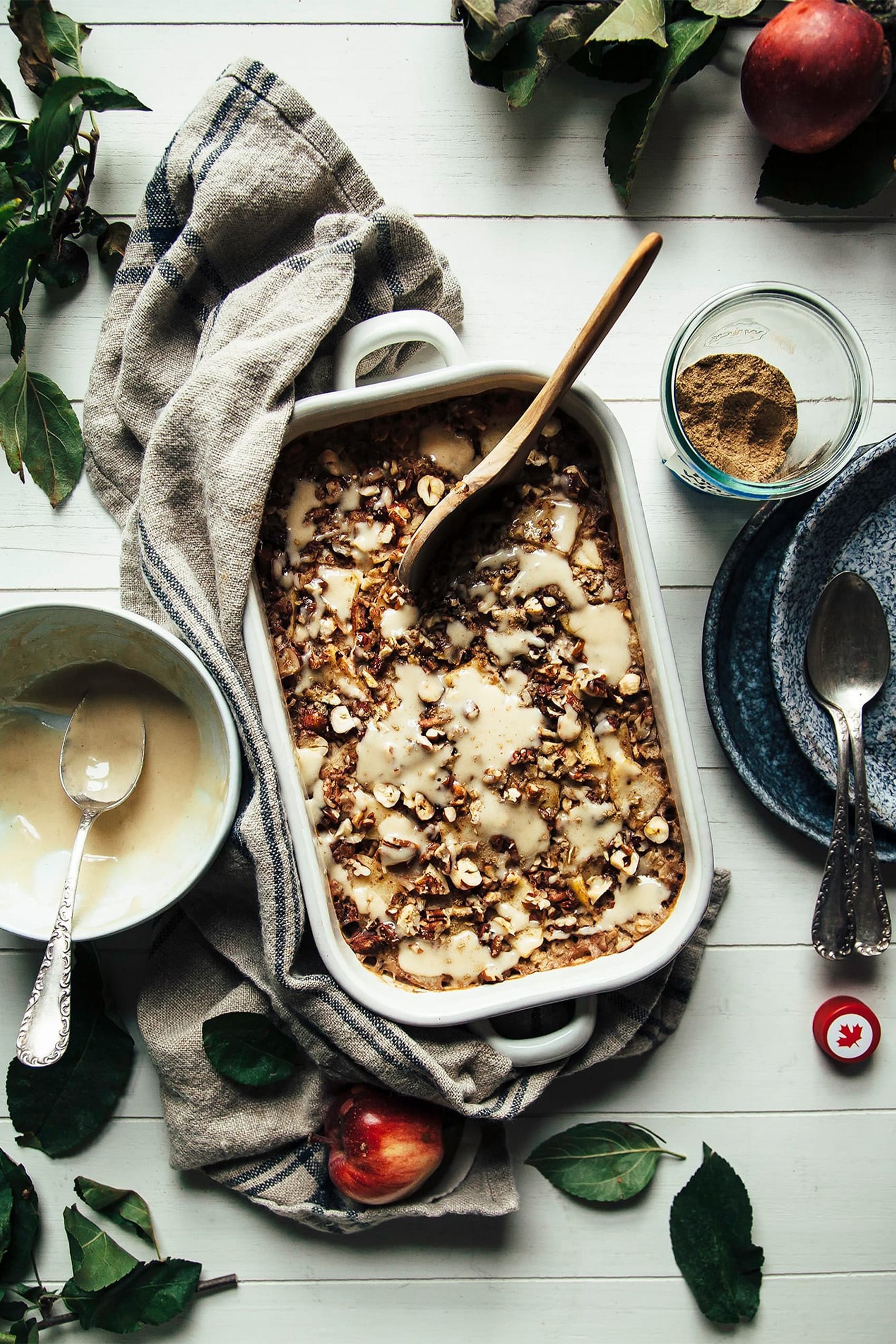 a casserole dish filled with baked oatmeal being served with a wooden spoon