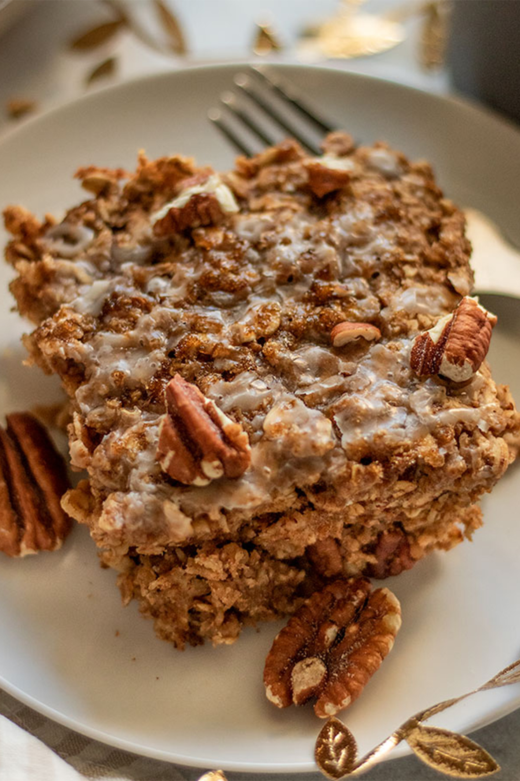 a slice of maple pecan baked oatmeal topped with fresh chopped pecans